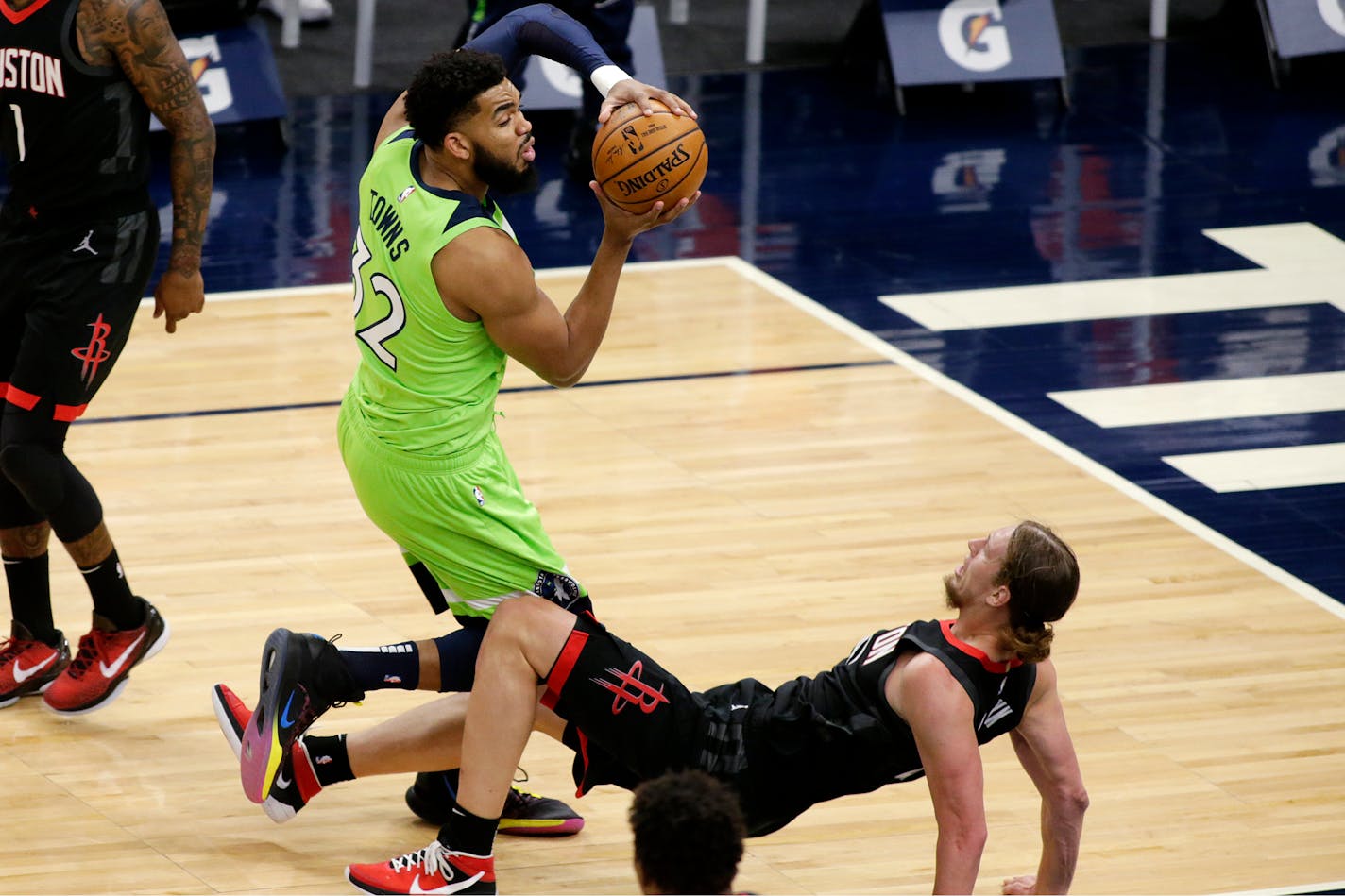 Houston Rockets center Kelly Olynyk (41) tries to take a charge but fouls Minnesota Timberwolves center Karl-Anthony Towns (32) during the first half of NBA basketball game Saturday, March 27, 2021, in Minneapolis. (AP Photo/Andy Clayton-King)