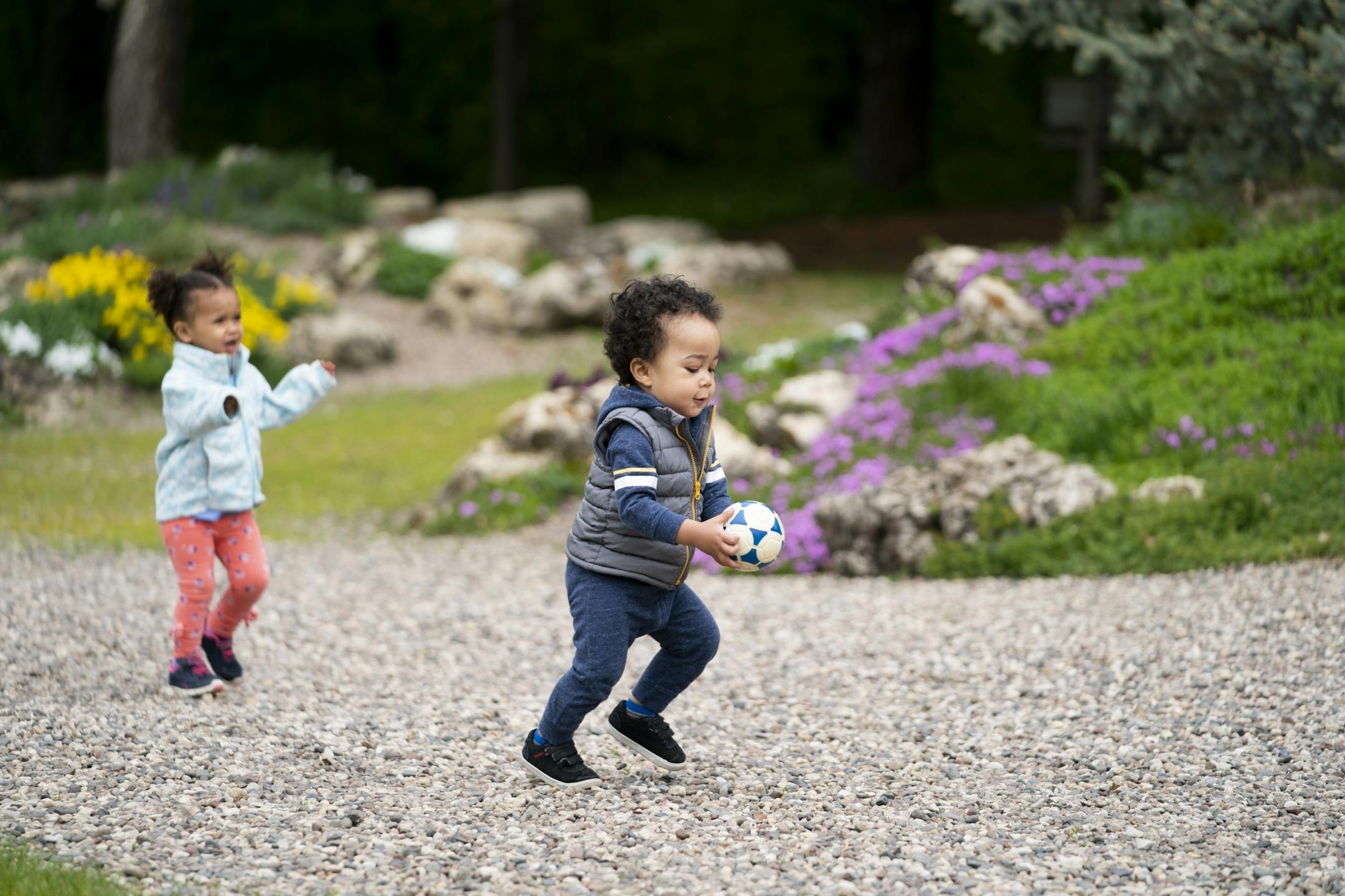 Nadya Jelinek , 2, chased Esai Hodge, 17 months, as they played with a ball at the Peace Garden with their moms in Minneapolis, Minn., on Tuesday, May 21, 2019.