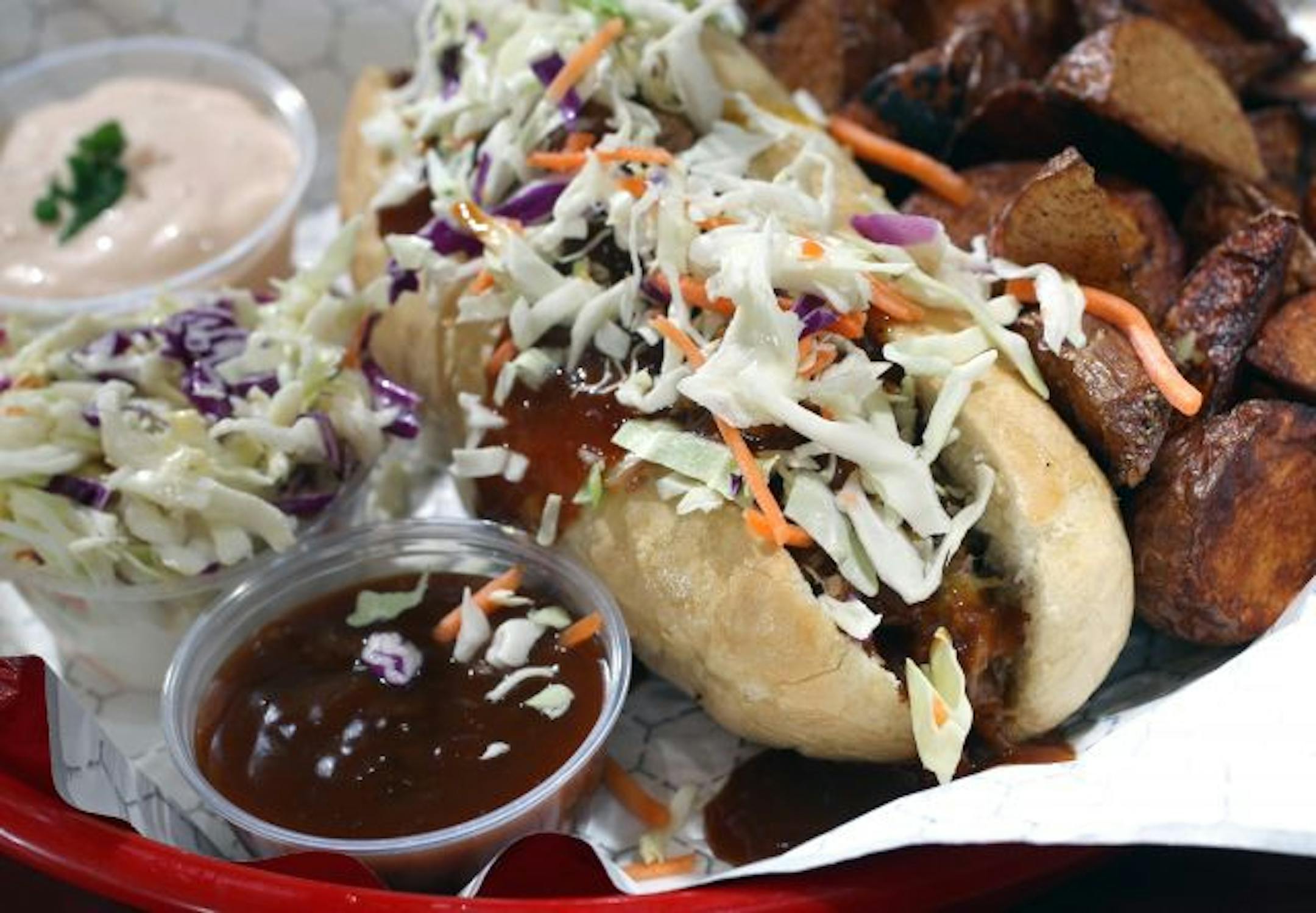 Q Fanatic serves up a pulled pork sandwich with spicy potatoes and coleslaw. Sauce is as it should be: on the side.