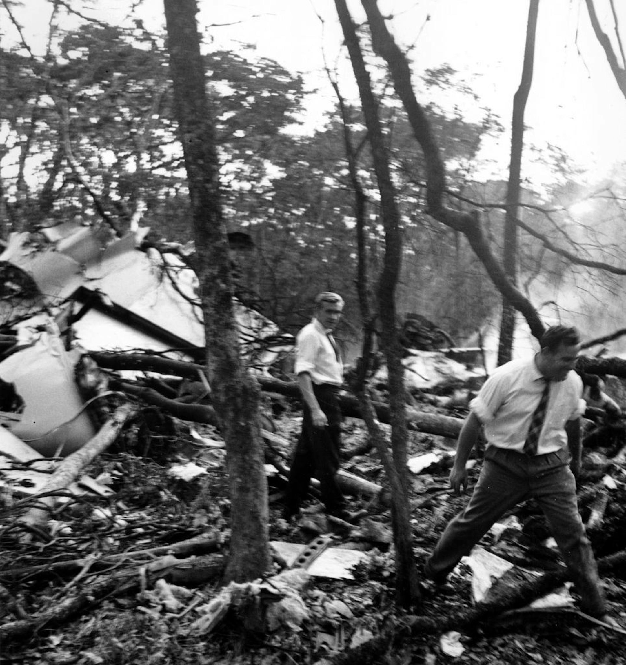 FILE - In this Sept. 19, 1961 file photo, searchers walk through the scattered wreckage of the DC6B plane in a forest near Ndola, Zambia, a crash in which U.N. Secretary-General Dag Hammarskjold was killed.
