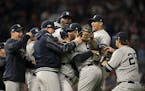 New York Yankees closer Aroldis Chapman (54) was mobbed by teammates after the Yankees defeated the Twins.