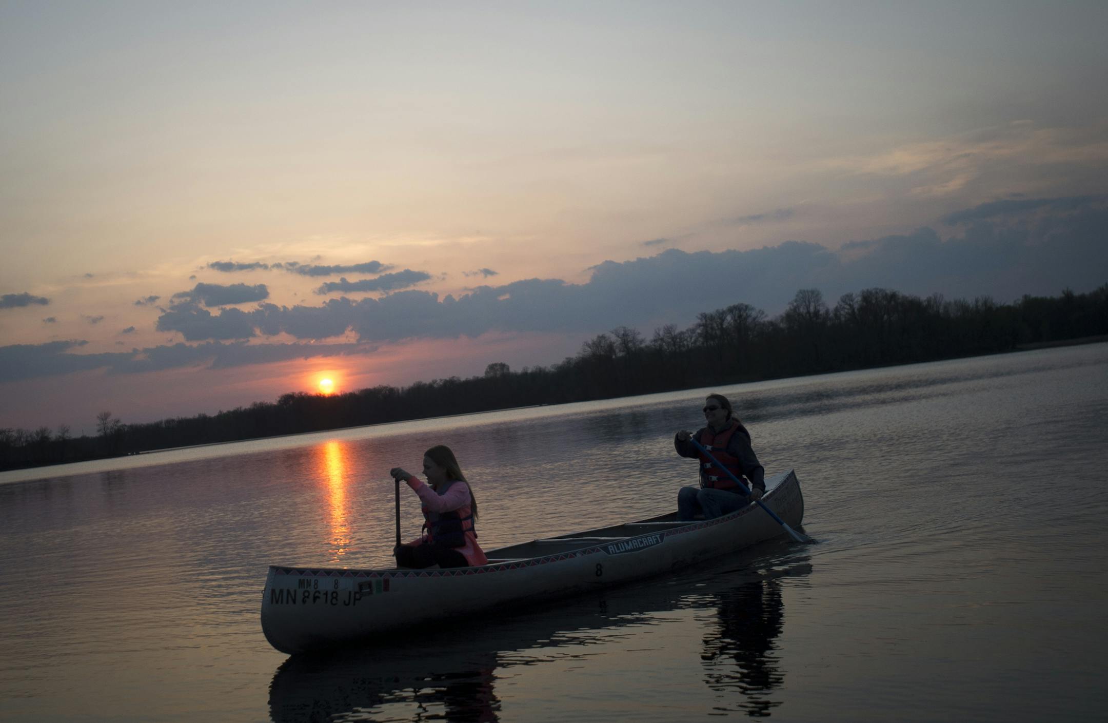 Jessica Krocak and her mother, Ann Krocak, canoe across Cleary Lake at sunset on Friday night. ] (Aaron Lavinsky | StarTribune) aaron.lavinsky@startribune.com Three Rivers Parks District has figured out the full moon is a time of celebration. They offer some kind of night excursion for every full moon. This spring and summer it's canoeing. We photographed an hour-long canoe trip on Friday, May 1, 2015 at Cleary Lake.