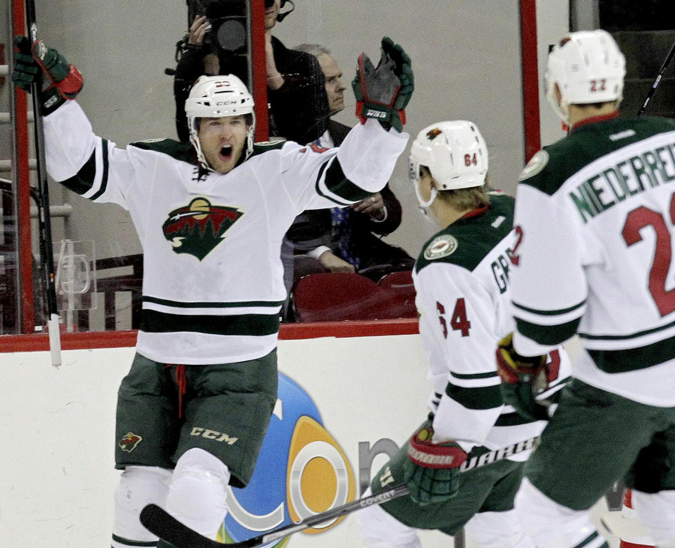 Jason Pominville, left, of the Minnesota Wild celebrates his goal with teammates Mikael Granlund (64) and Nino Niederreiter (22) while Jay Harrison of the Carolina Hurricanes looks on in the first period at the PNC Arena in Raleigh, N.C., on Saturday, Nov. 9, 2013. Minnesota won, 3-2, in a shootout. (Chris Seward/Raleigh News & Observer/MCT)