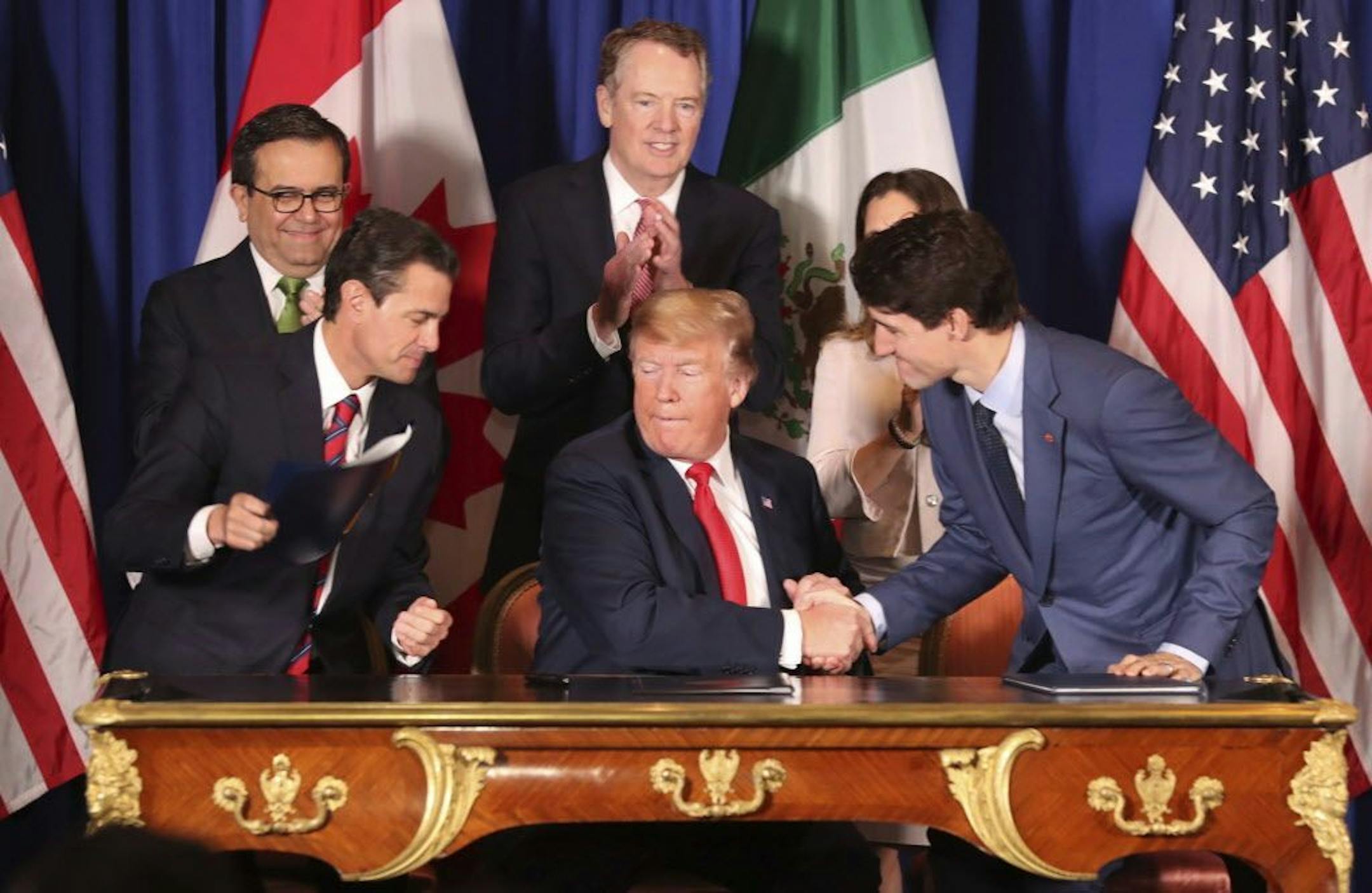 President Donald Trump, center, shakes hands with Canada's Prime Minister Justin Trudeau as Mexico's President Enrique Pena Nieto looks on after they signed a new United States-Mexico-Canada Agreement that is replacing the NAFTA trade deal, during a ceremony at a hotel before the start of the G20 summit in Buenos Aires, Argentina, Friday, Nov. 30, 2018. The USMCA, as Trump refers to it, must still be approved by lawmakers in all three countries.