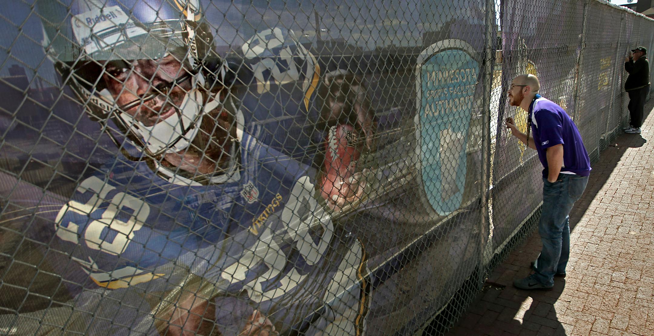 Minnesota Vikings fan Bill Thompson, left, and his wife Kristin Thompson took a look at the Vikings stadium construction site, Saturday, September 13, 2014. Thompson, from Atlanta, GA, is here for tomorrow's game. He said he remembers getting the belt to him when he was little. l ] (ELIZABETH FLORES/STAR TRIBUNE) ELIZABETH FLORES ‚Ä¢ eflores@startribune.com ORG XMIT: MIN1409131435200781 ORG XMIT: MIN1409131450460782