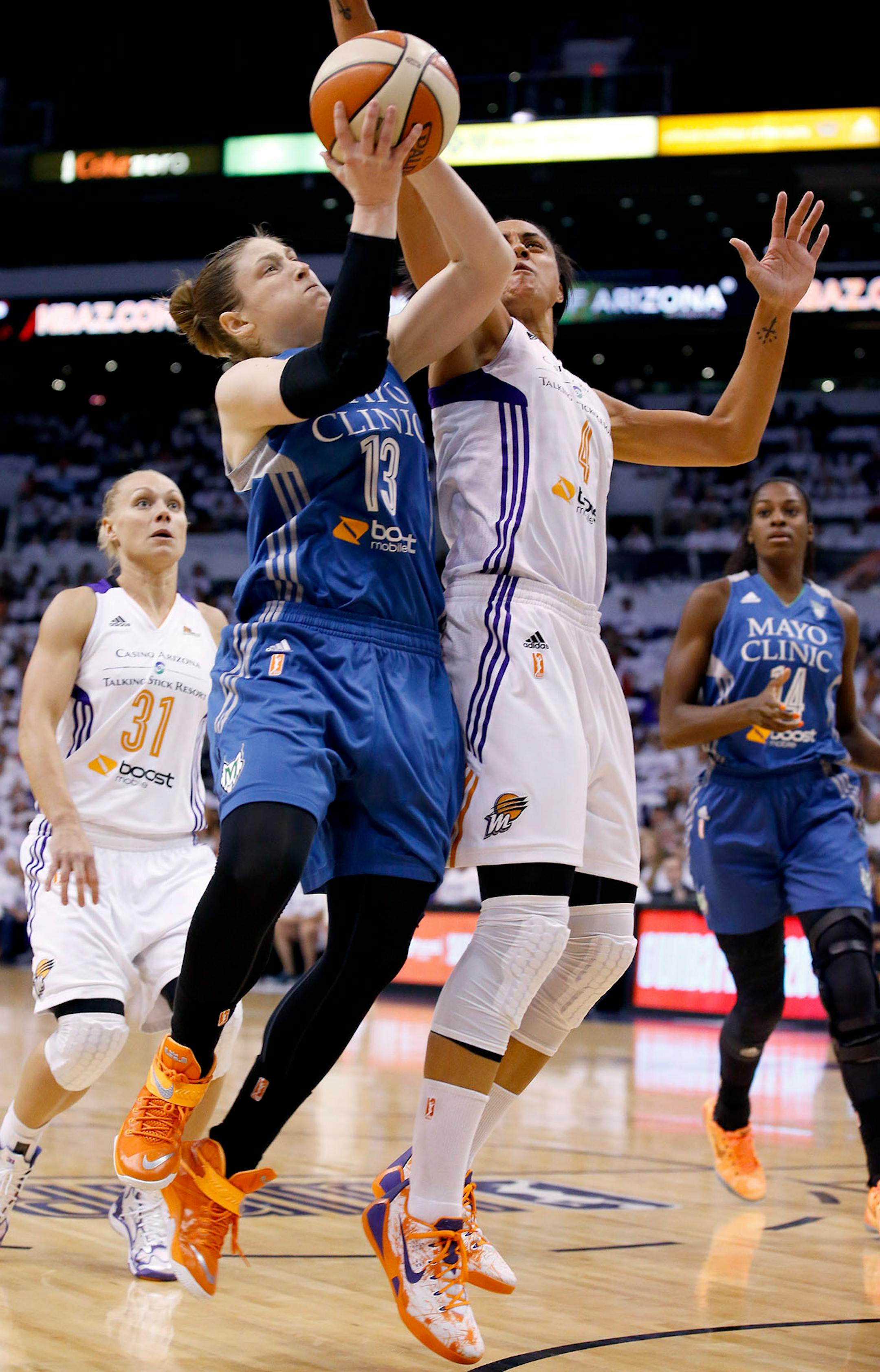 Minnesota Lynx's Lindsay Whalen (13) tries to get off a shot as Phoenix Mercury's Candice Dupree (4) defends while Mercury's Erin Phillips (31), of Australia, and Lynx's Devereaux Peters, right, look on during the first half in Game 1 of the WNBA Western Conference Finals Friday, Aug. 29, 2014, in Phoenix. (AP Photo/Ross D. Franklin)