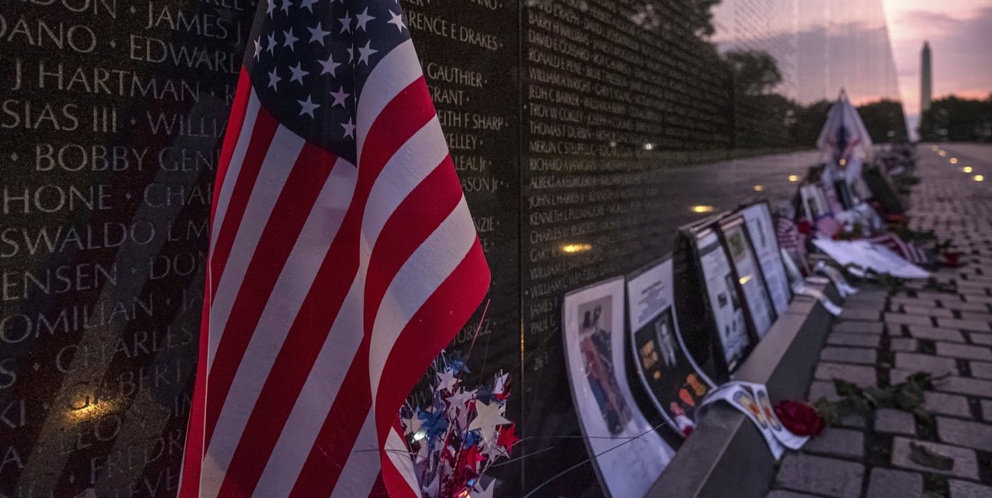 A U.S. Flag rests against the Memorial Wall of the Vietnam Veterans Memorial in Washington at daybreak on Memorial Day Monday, May 27, 2019. (AP Photo/J. David Ake)