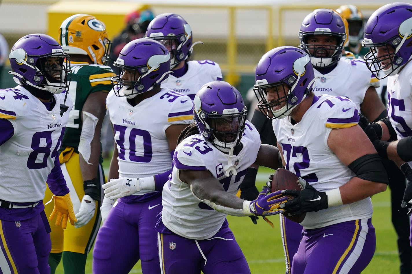 Vikings running back Dalvin Cook (33) celebrated with offensive tackle Ezra Cleveland (72) after scoring a touchdown in the third quarter at Green Bay.