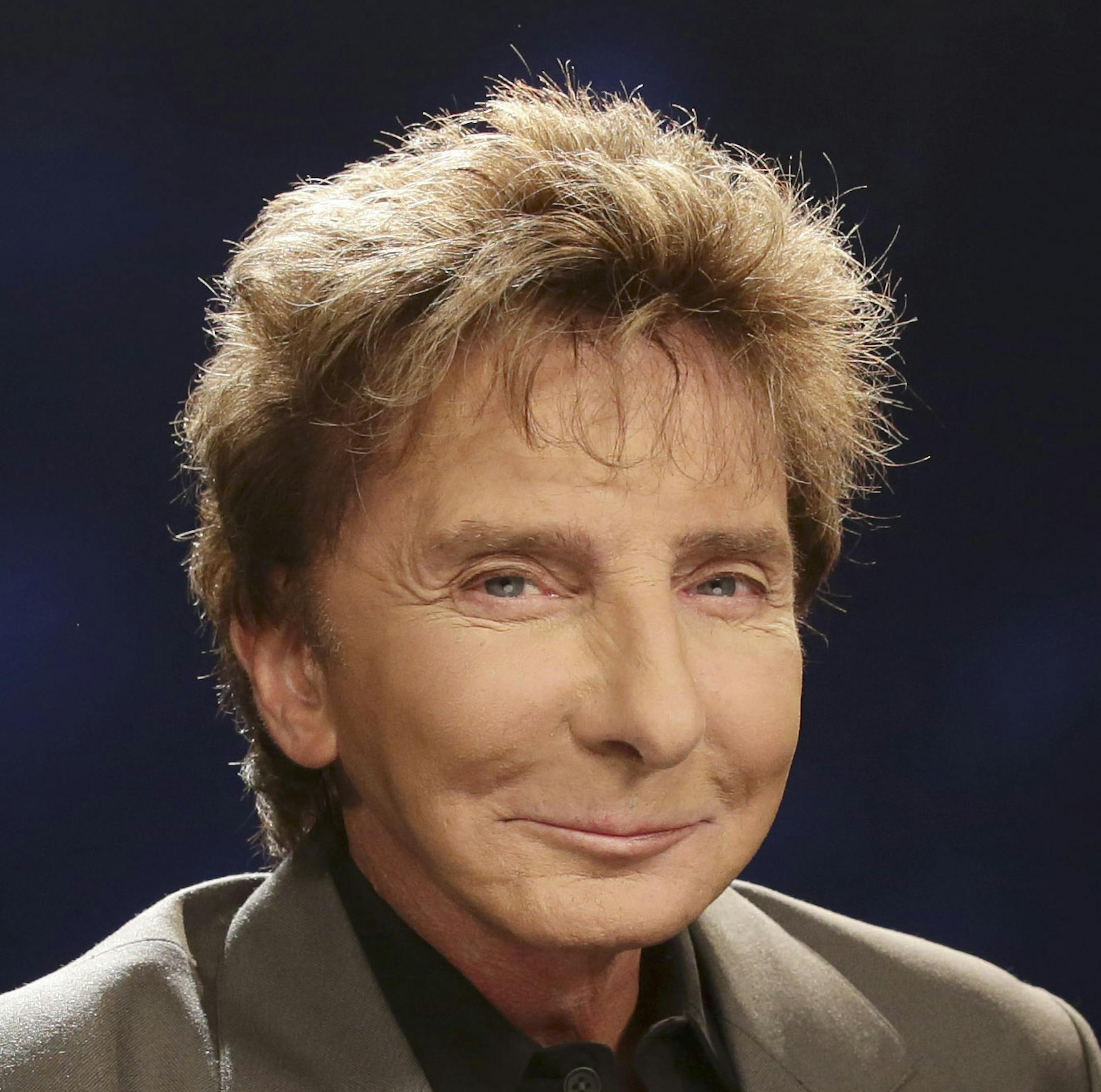 FILE - In this Oct. 27, 2014 file photo, singer-songwriter and producer Barry Manilow poses for a photograph during an interview in New York. Manilow has been forced to postpone two concerts following a rough week of oral surgery. Manilow had surgery twice earlier this week, and still managed to make a concert in Memphis on Wednesday. But after that, he was brought back to Los Angeles for surgery Friday when complications developed. (AP Photo/Kathy Willens, File)