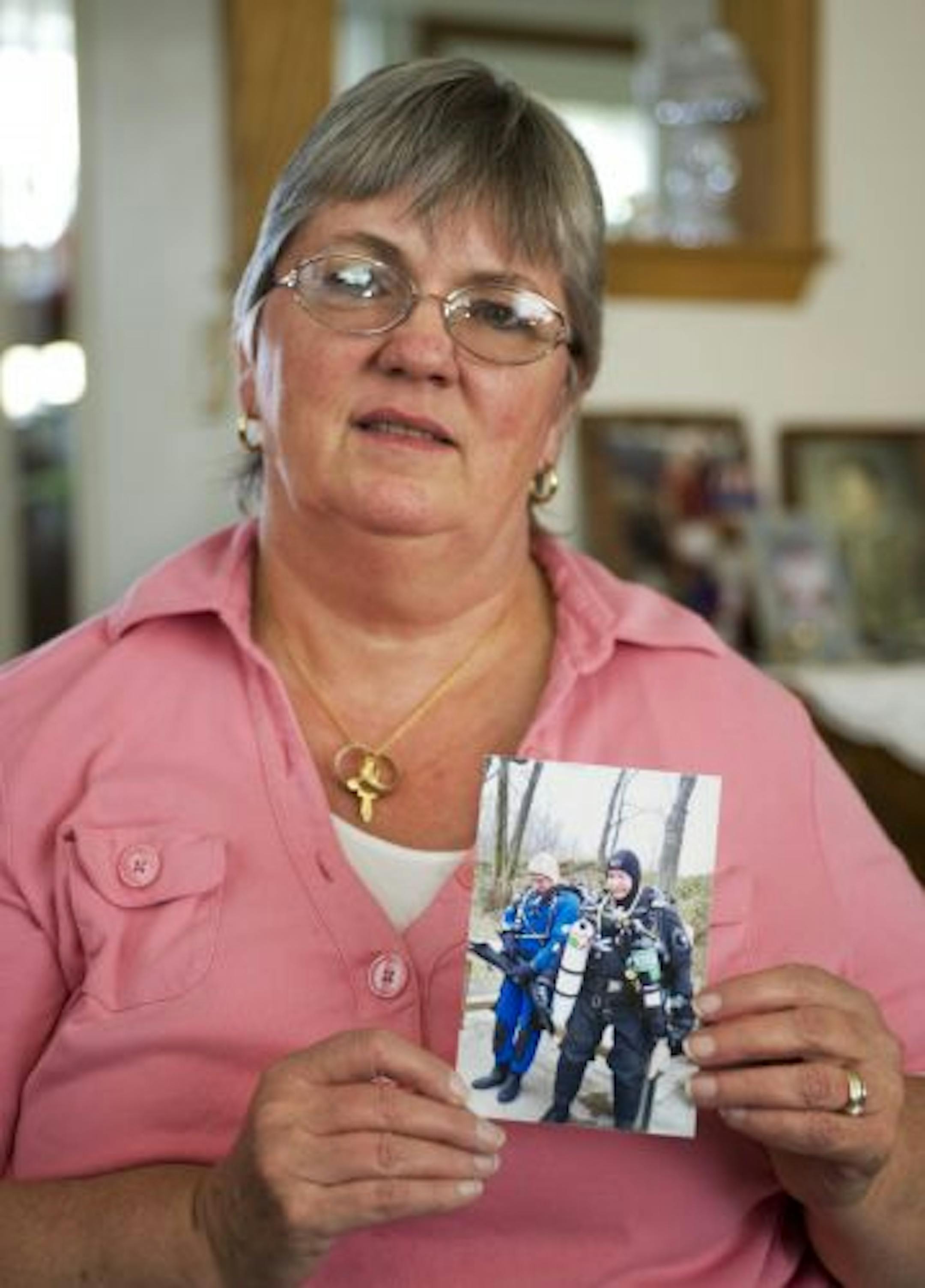 C.J.Floyd with photo of her husband, Milt Floyd, right, and his diving buddy, Jim Jordan, left. Both men died after an incident at Lake Wazee, a popular dive destination in Wisconsin..
