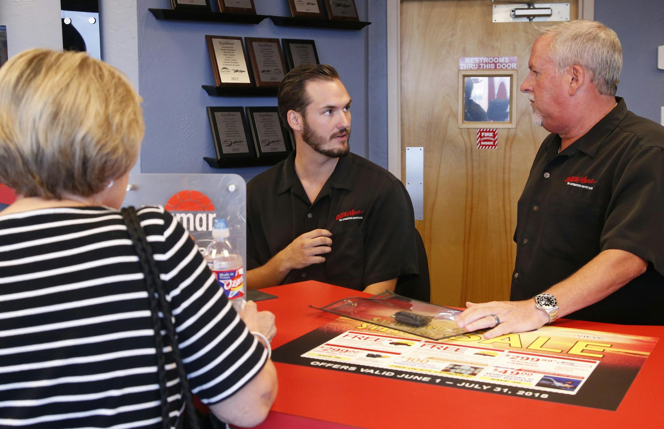 In this July 10, 2018, photo, Greg Goodman, right, and his son Chandler Goodman, center, help a customer at the counter, in their Alta Mere franchise in Oklahoma City. The plan was for Greg Goodman to sell his auto supply store and retire about the time he turned 60. Then Plan B came along - son Chandler decided to join and eventually take over the family business instead of becoming an architect. (AP Photo/Sue Ogrocki) ORG XMIT: OKSO302