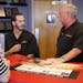 In this July 10, 2018, photo, Greg Goodman, right, and his son Chandler Goodman, center, help a customer at the counter, in their Alta Mere franchise 