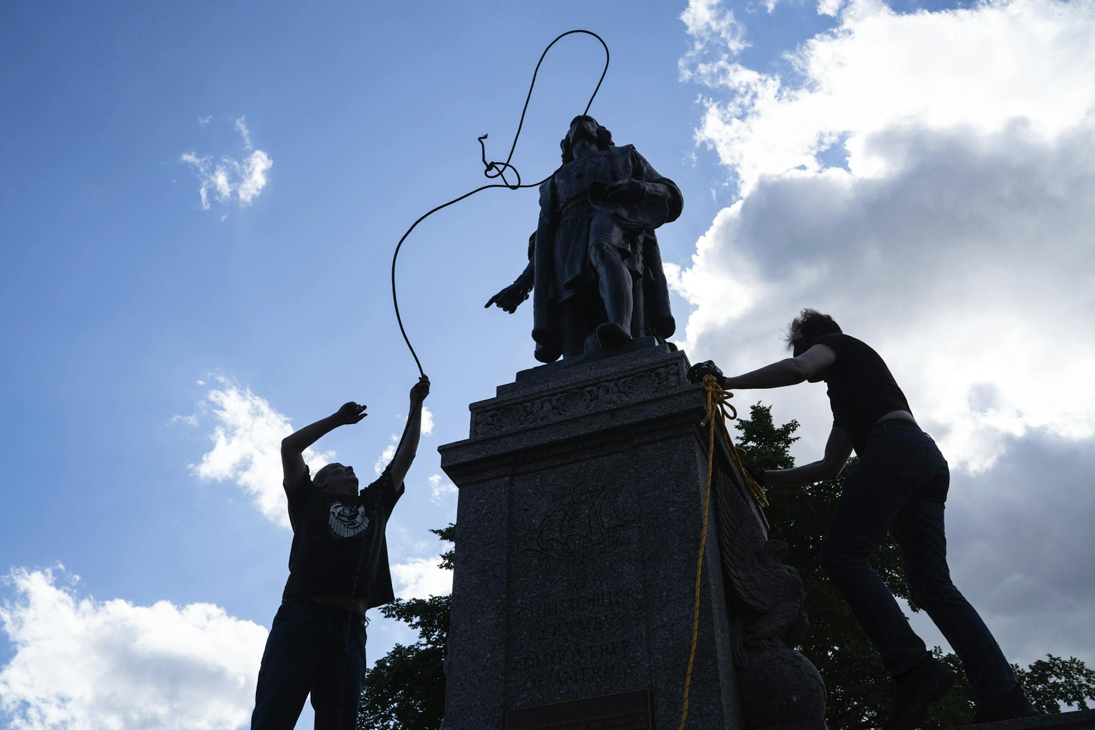 Mike Forcia, left, and another man fasten ropes around the neck of a statue of Christopher Columbus at the Minnesota state Capitol in St. Paul, Minn., Wednesday, June 10, 2020. (Evan Frost/Minnesota Public Radio via AP)