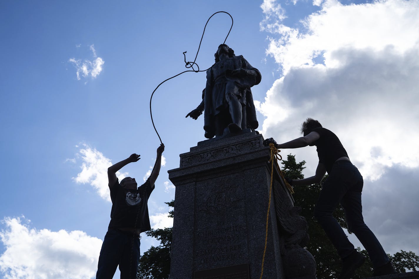 Mike Forcia, left, and another man fasten ropes around the neck of a statue of Christopher Columbus at the Minnesota state Capitol in St. Paul, Minn., Wednesday, June 10, 2020. (Evan Frost/Minnesota Public Radio via AP)