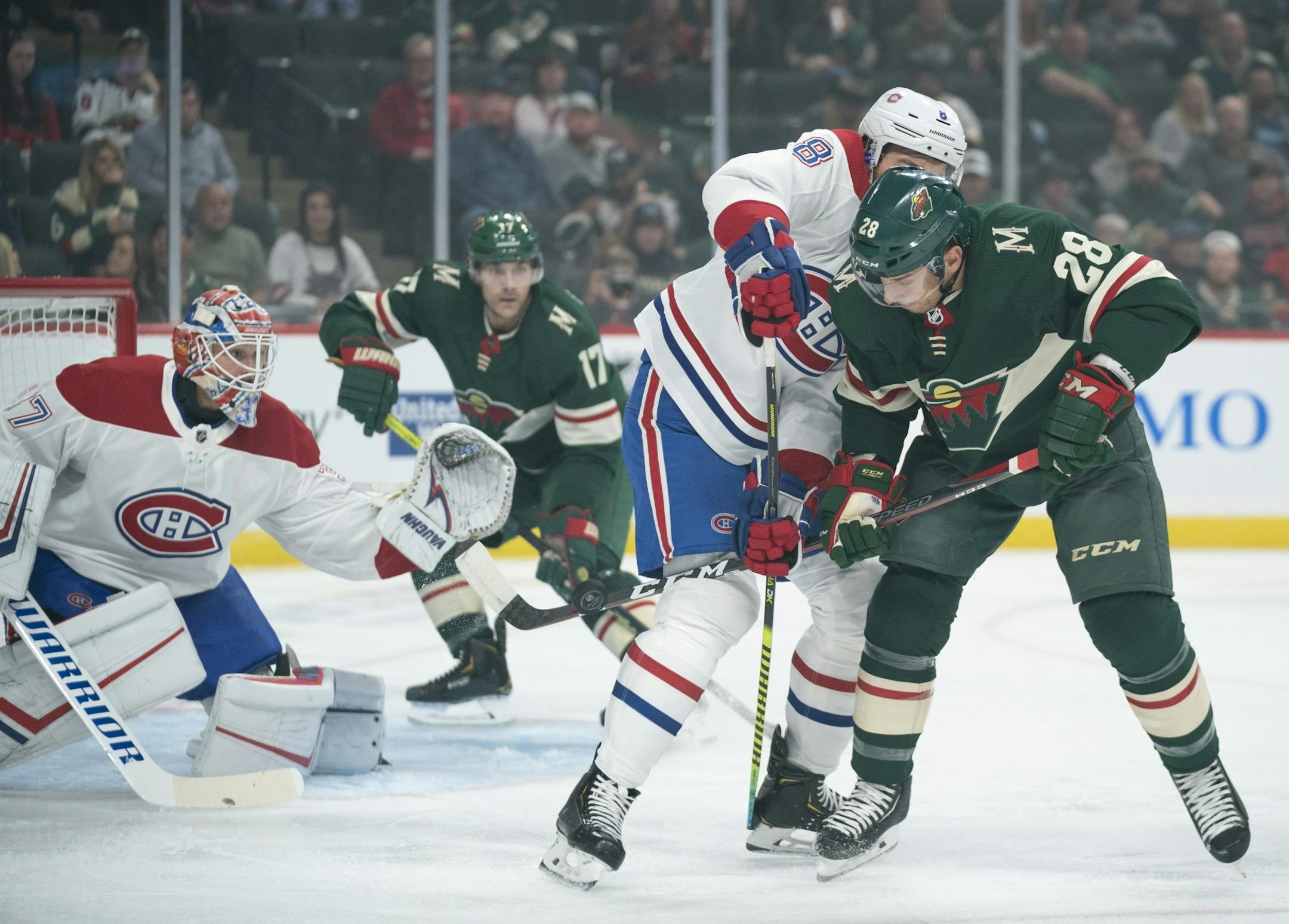 Minnesota Wild center Gabriel Dumont (28) deflected a first period shot while tied up with Montreal Canadiens defenseman Ben Chiarot (8).