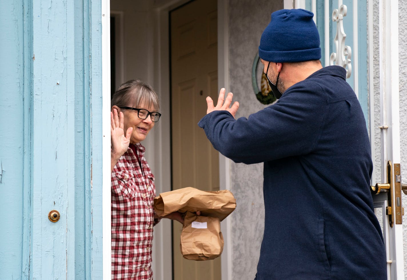 Jacqueline Cable thanks Pete Magnuson outside her home after he delivered her meals as part of the TRUST Meals on Wheels program Thursday, Nov. 18, 2021 in Minneapolis. ]