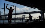FILE -- People exercise at a public park along the East River on Manhattan's Lower East Side, June 10, 2015. A new analysis of data from more than 55,