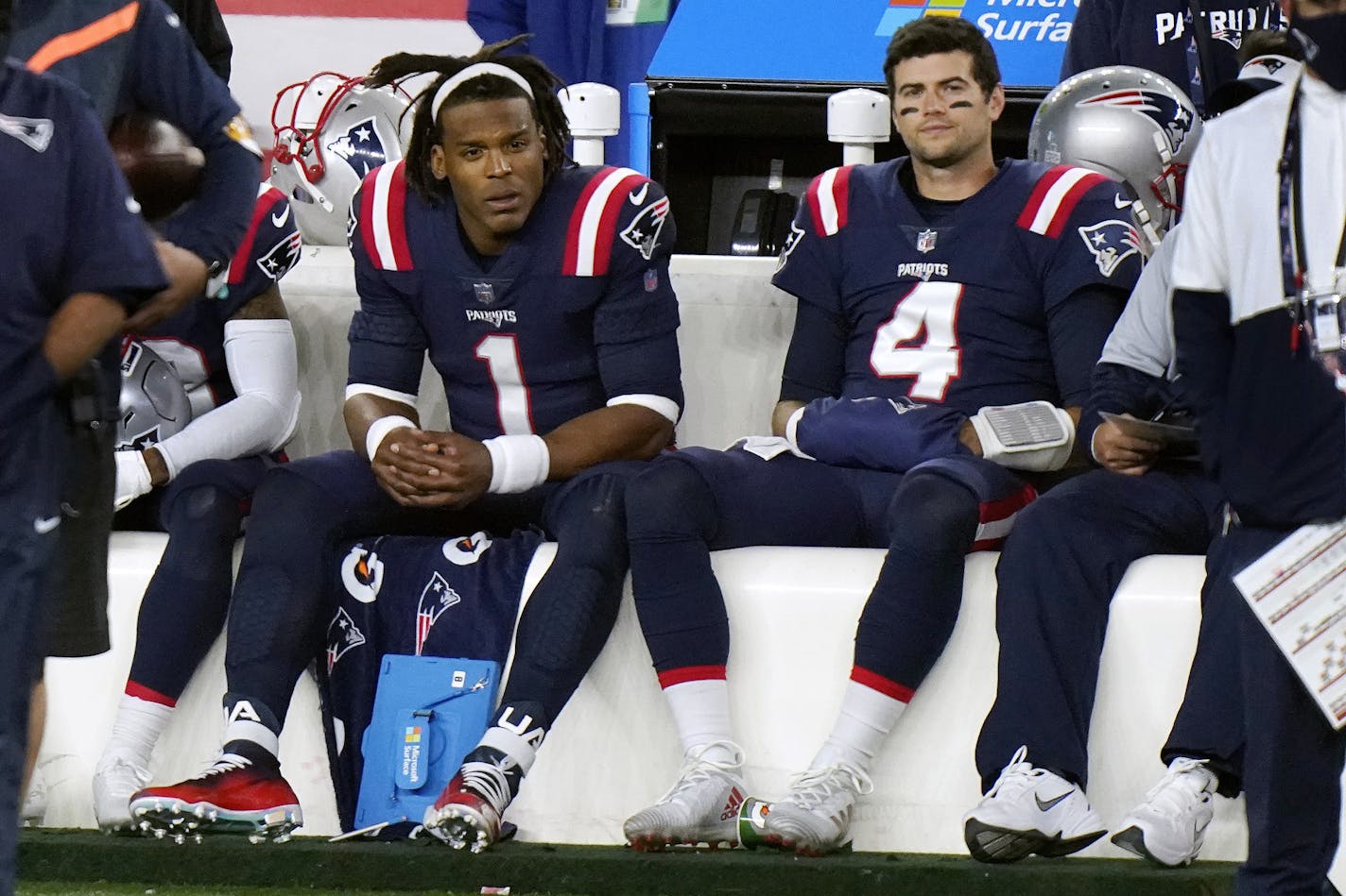 New England Patriots quarterbacks Cam Newton, left, and Jarrett Stidham sit on the bench in the second half of an NFL football game against the San Francisco 49ers, Sunday, Oct. 25, 2020, in Foxborough, Mass. (AP Photo/Steven Senne)