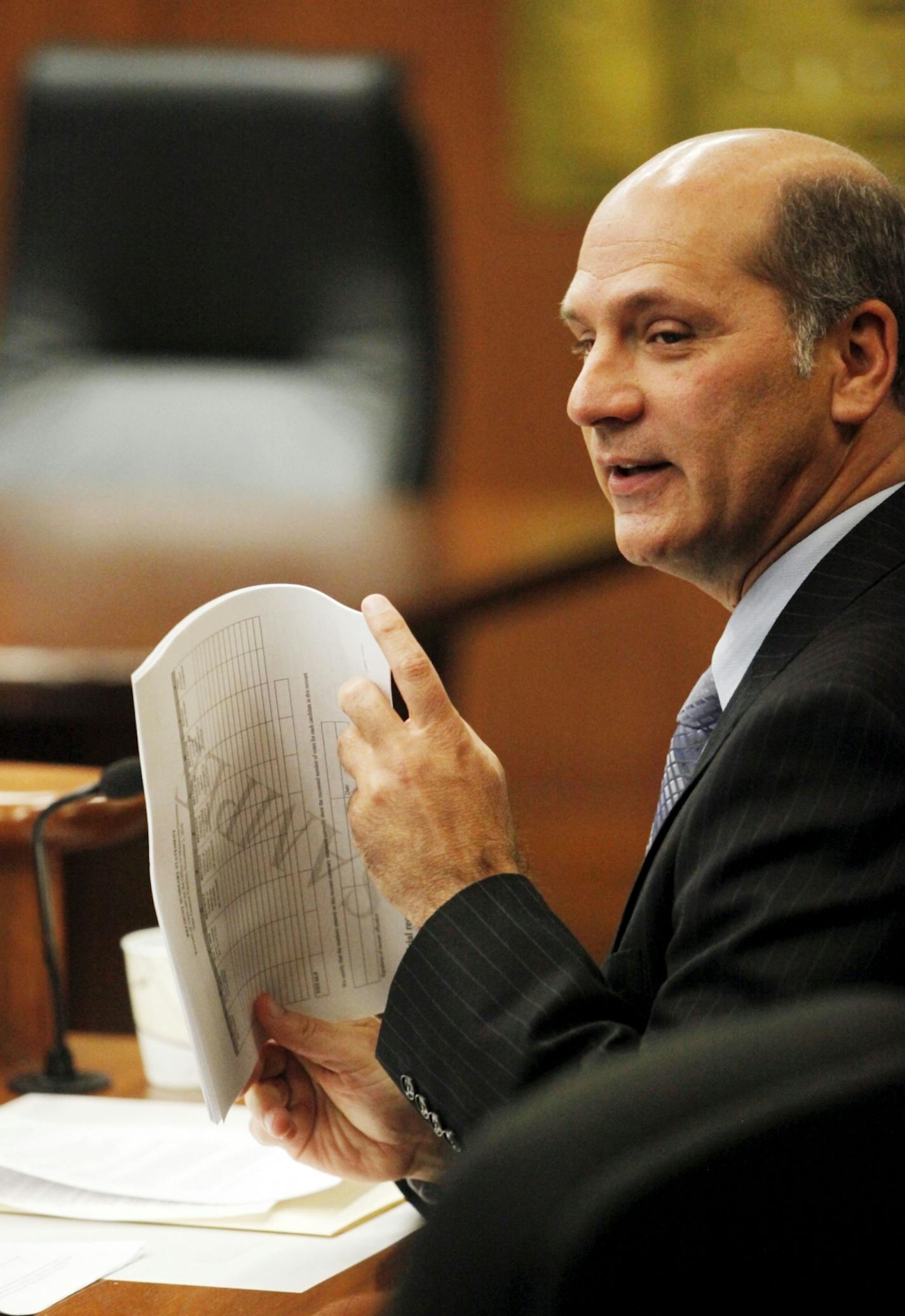 Director of elections Gary Poser holds a copy of the final election report before the canvassing board signed off on the recount.