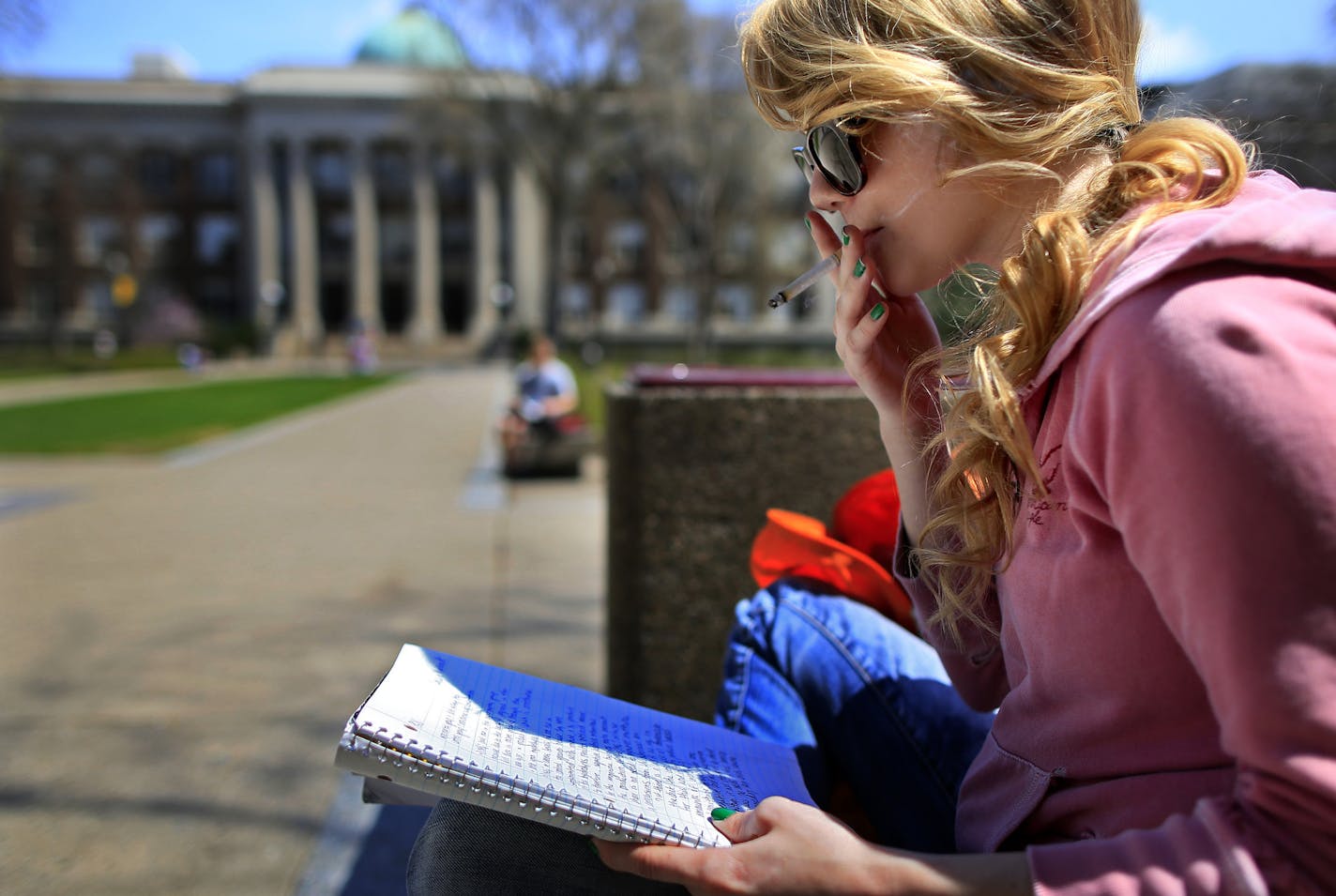 The U of M is finally banning smoking in outdoor spaces, something that Cassie Verbout of Cottage Grove doesn't think will go over too well. Verbout was having a smoke while studying on the Northrup Mall Monday afternoon. ] BRIAN PETERSON &#x201a;&#xc4;&#xa2; brianp@startribune.com MINNEAPOLIS, MN - 05/06/2013