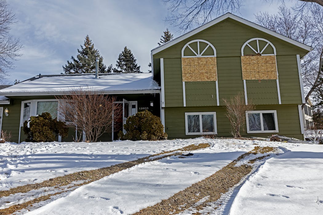 The Burnsville house where two police officers and a paramedic were shot and killed by a gunman sat boarded up Monday.