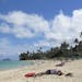This Oct. 29, 2013 photo shows people at Lanikai Beach, a popular neighborhood for vacation rentals, in Kailua, Hawaii. Airbnb Inc. is agreeing to pro
