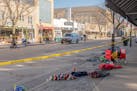 Police patrol along a parade route where abandoned items remain on a street in Waukesha, Wis., on Monday, after the driver of an SUV plowed into a Chr