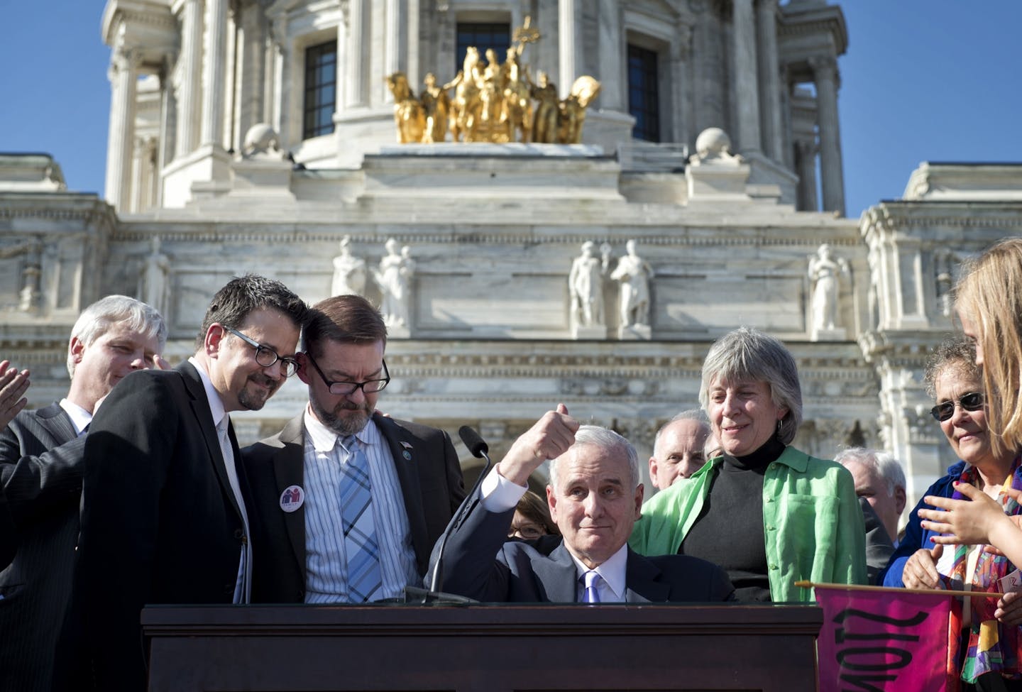 Gov. Mark Dayton signed the marriage bill into law Tuesday, in front he the Capitol. With him were bill authors Sen. Scott Dibble with his partner Mark Leyva and Rep. Karen Clark with her partner Jacqueline Zita and all the legislators who voted yes.