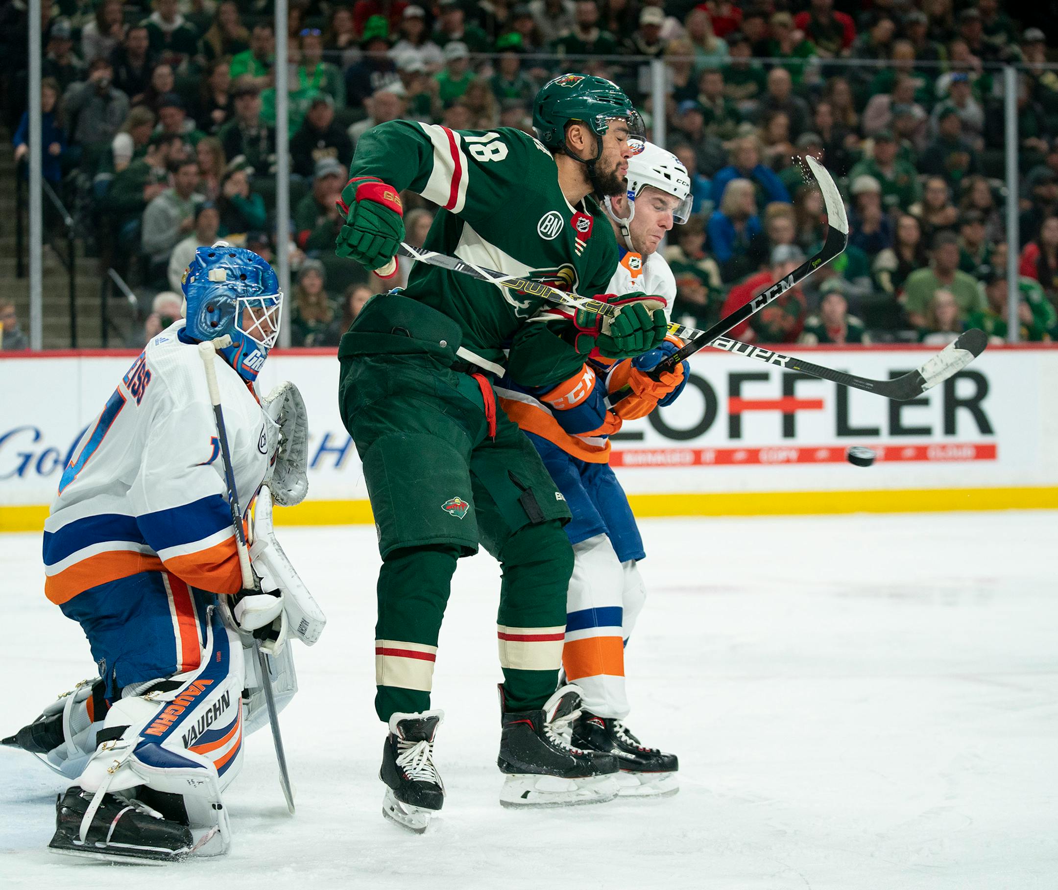 Minnesota Wild left wing Jordan Greenway (18) tries to deflect an incoming shot while defended by New York Islanders defenseman Devon Toews (25) in front of Islanders goaltender Thomas Greiss in the second period on Sunday, March 17, 2019 at Xcel Energy Center in St. Paul, Minn. (Jeff Wheeler/Minneapolis Star Tribune/TNS) ORG XMIT: 1284952