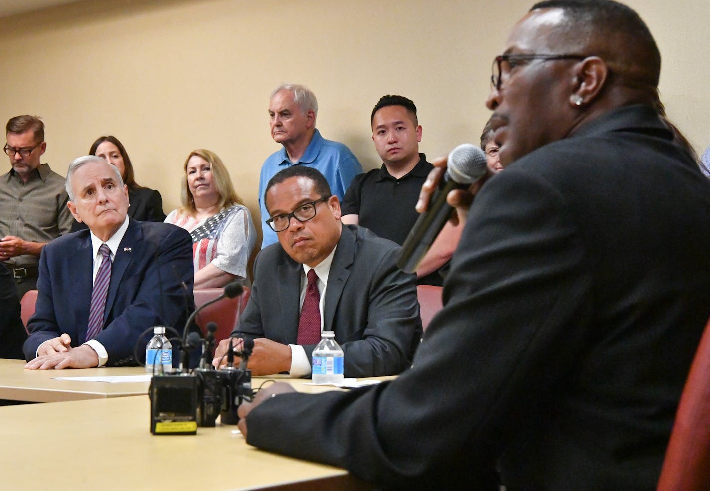 Gov. Mark Dayton, at left, with U.S. Rep. Keith Ellison, listened as James Robinson, right, spoke of how Medicaid helped him.