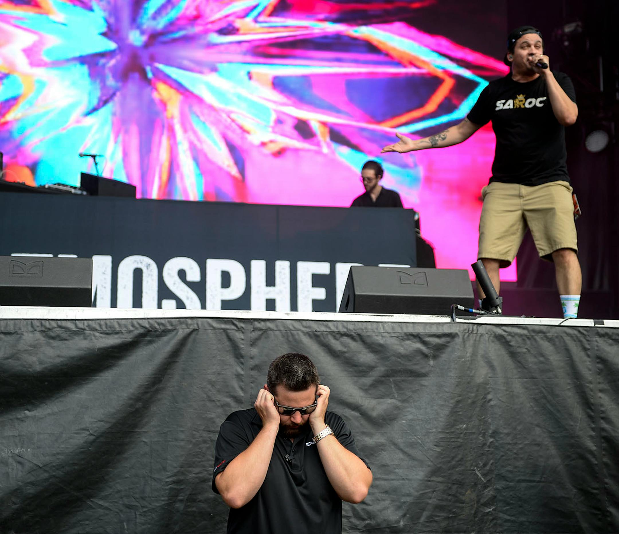A stadium worker plugged his ears as Atmosphere performed behind him Sunday evening.