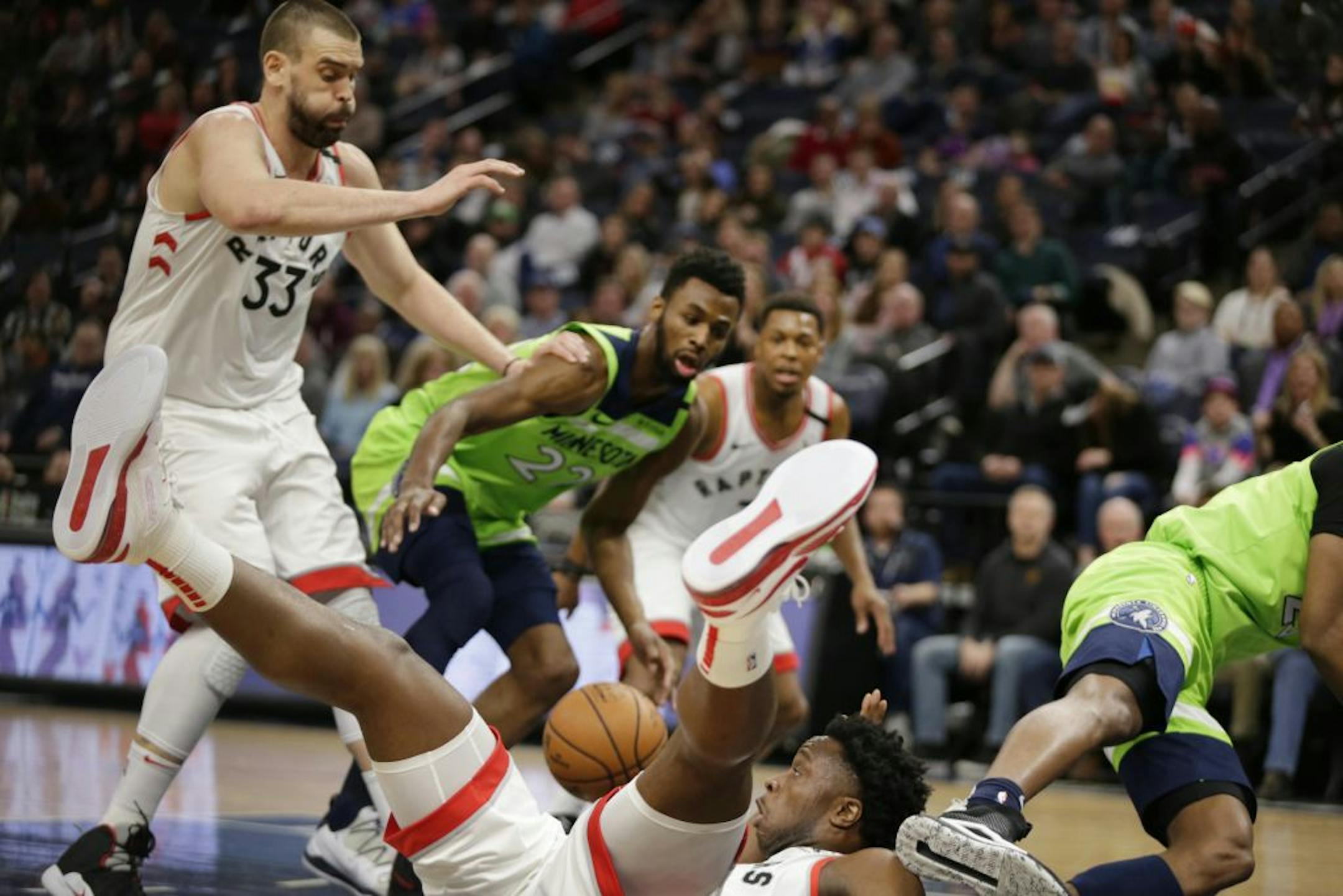 Toronto Raptors guard Kyle Lowry loses the ball as he falls while teammate Marc Gasol (33) and Minnesota Timberwolves forward Andrew Wiggins (22) look on in the second quarter of an NBA basketball game Saturday, Jan. 18, 2020, in Minneapolis.