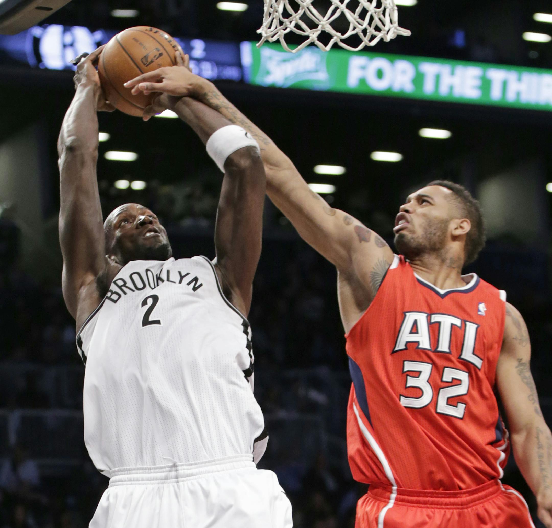Atlanta Hawks forward Mike Scott (32) fouls Brooklyn Nets forward Kevin Garnett (2) in the first half of their NBA basketball game at the Barclays Center, Monday, Jan. 6, 2014, in New York. (AP Photo/Kathy Willens)