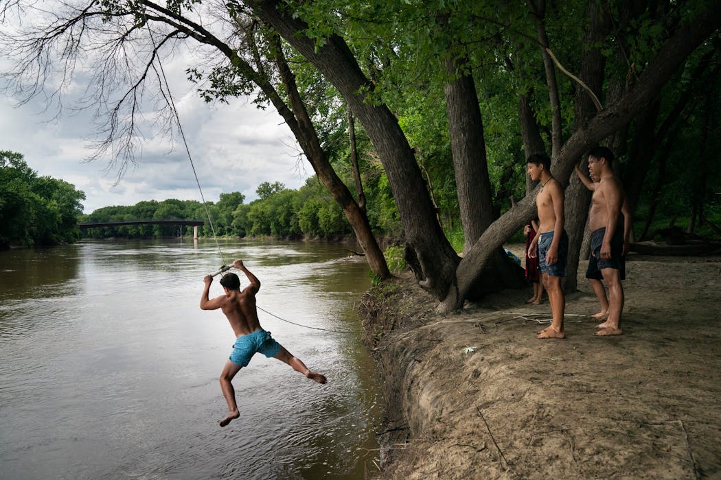A group of friends use a rope swing on the Minnesota River in Bloomington in 2020.