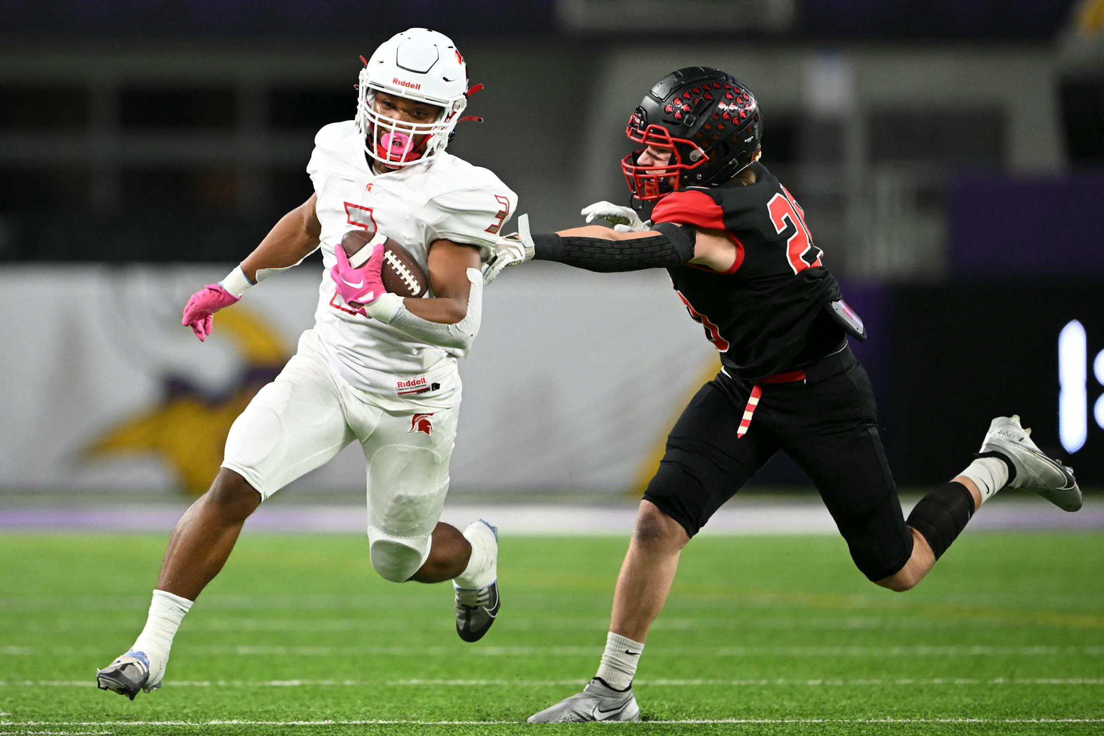 Simley running back David Gogins (3) rushes the ball against Simley defensive back Wyatt Busta (20) during the first half.