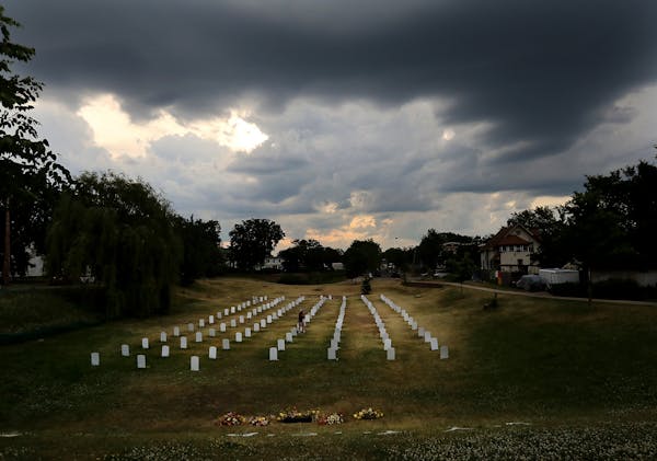 Storm clouds hang over the "Say Their Names Cemetery," located in a grassy area along Park Ave. S., near 37th St., dedicated to people of color killed