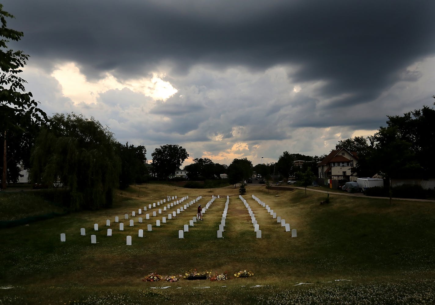 Storm clouds hang over the "Say Their Names Cemetery," located in a grassy area along Park Ave. S., near 37th St., dedicated to people of color killed by police and installed in the early days after the killing of George Floyd in Minneapolis police custody and seen Thursday, June 18, 2020, in Minneapolis, MN.