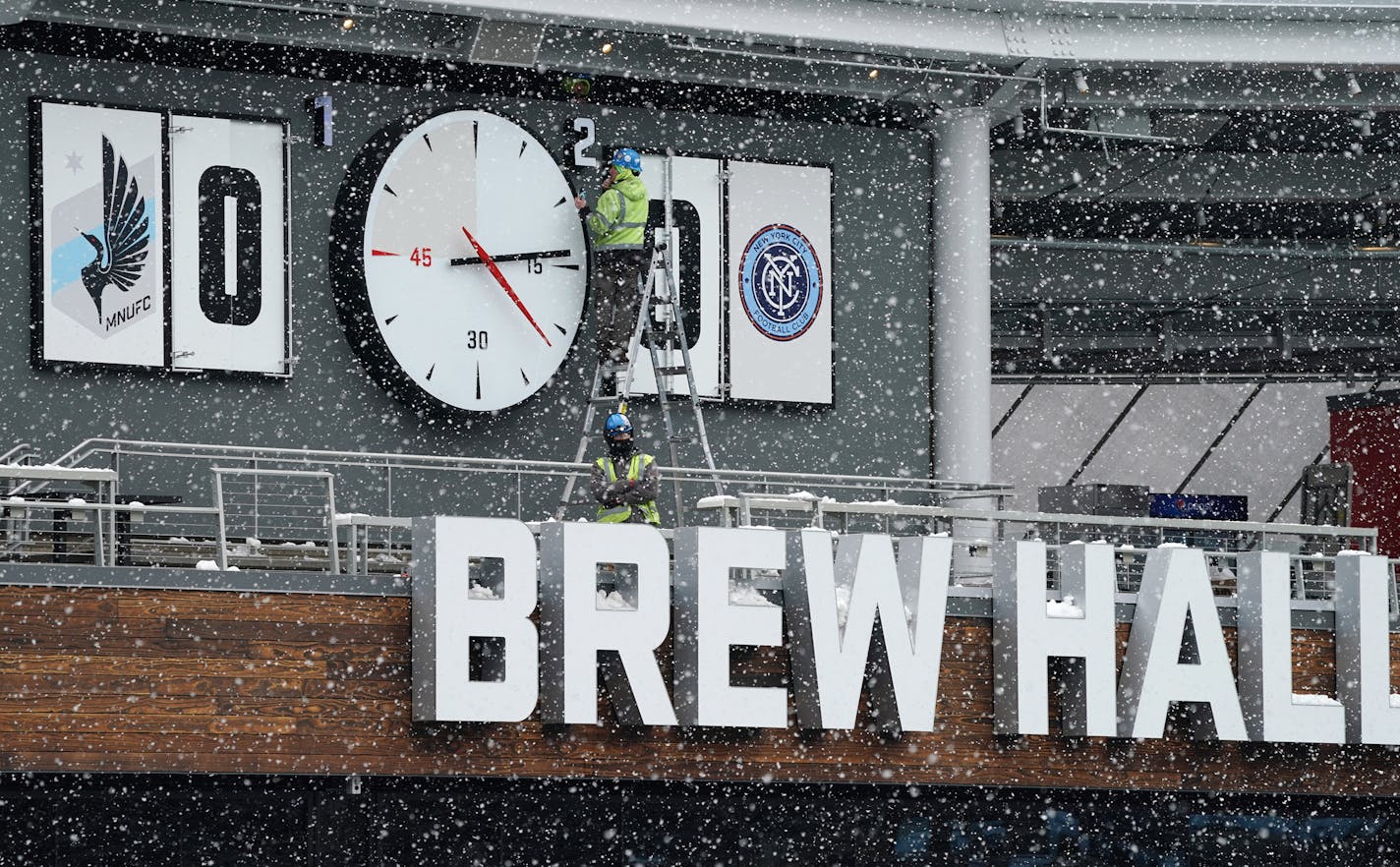 Crews worked to install the clock above the the Brew Hall Friday at Allianz Field amid heavy snow flurries ahead of Saturday's home opener. ] ANTHONY SOUFFLE &#x2022; anthony.souffle@startribune.com Crews cleared snow and ice as they readied Allianz Field for Saturday's home opener against the New York City Football Club Friday, April 12, 2019 in St. Paul, Minn.