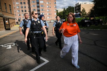 Aileen Johnson, with the Loring Park Safety Block Club, brought a group of Minneapolis police on a tour of the Woman’s Club during National Night Ou