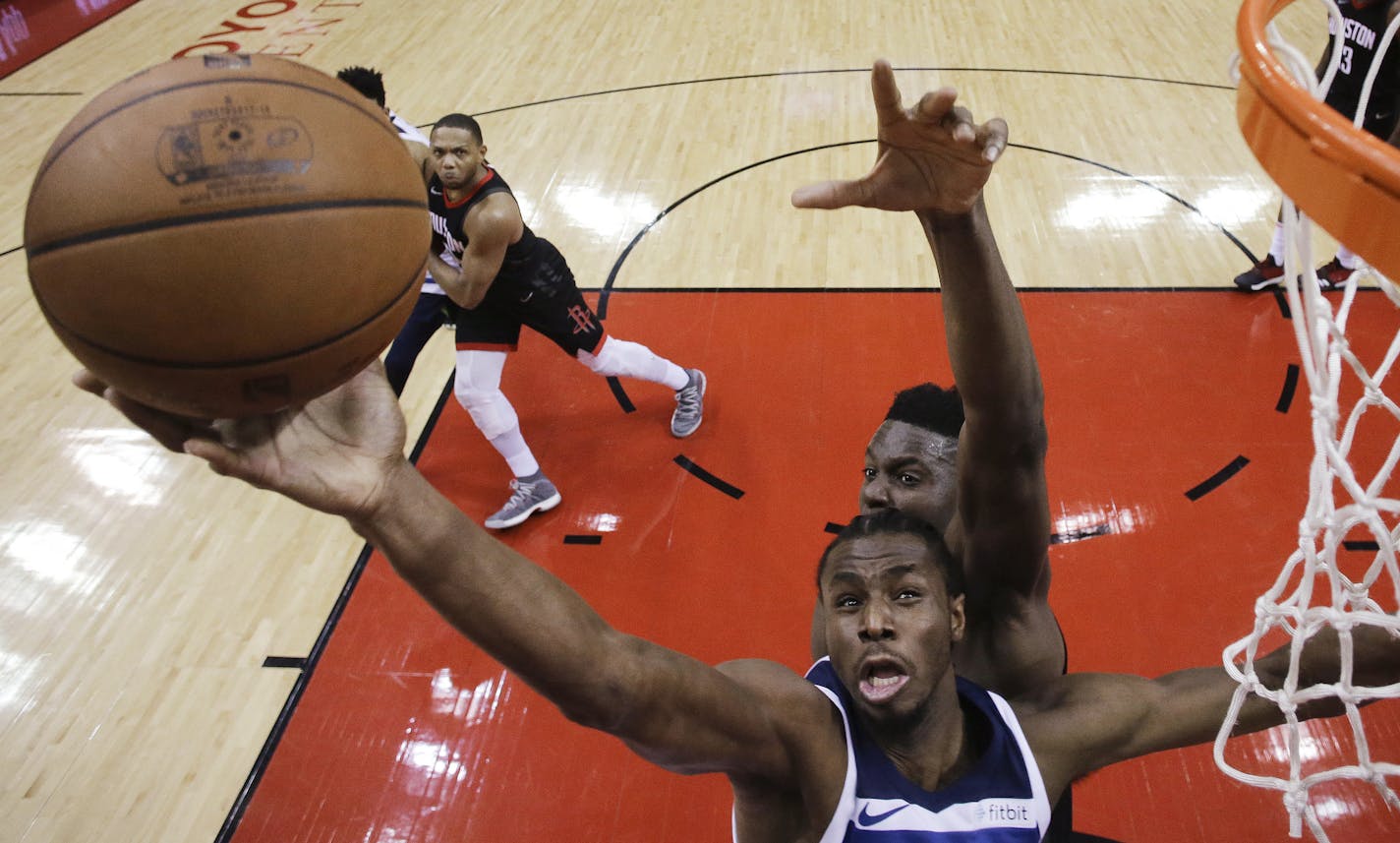 Minnesota Timberwolves forward Andrew Wiggins, bottom, shoots as Houston Rockets center Clint Capela defends during the second half in Game 5 of a first-round NBA basketball playoff series, Wednesday, April 25, 2018, in Houston. (AP Photo/Eric Christian Smith)