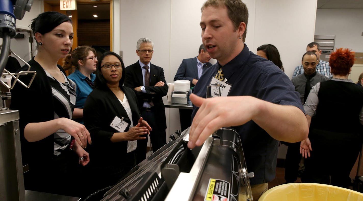 McDonald's restaurant general managers, from left, Heather Tackett, Sasha Singh and Jeffery Silvernail gather around a devise used to heat up hamburger buns in the Food Quality Lab at McDonald's University on April 14, 2015 in Oak Brook, Ill. (Antonio Perez/Chicago Tribune/TNS) ORG XMIT: 1167109