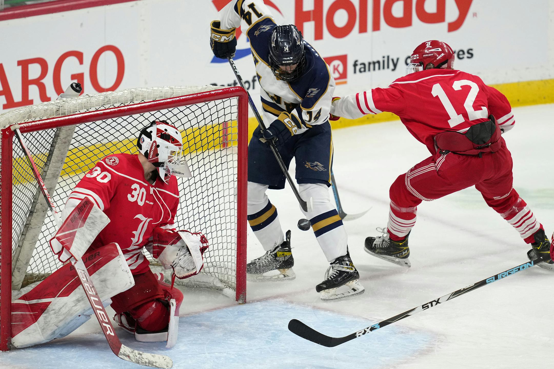Hermantown forward Aaron Evjen (14) scores on Luverne goaltender Tyler Arends (30) in the first period of a MSHSL Class 1A quarterfinal hockey game between Luverne and Hermantown.