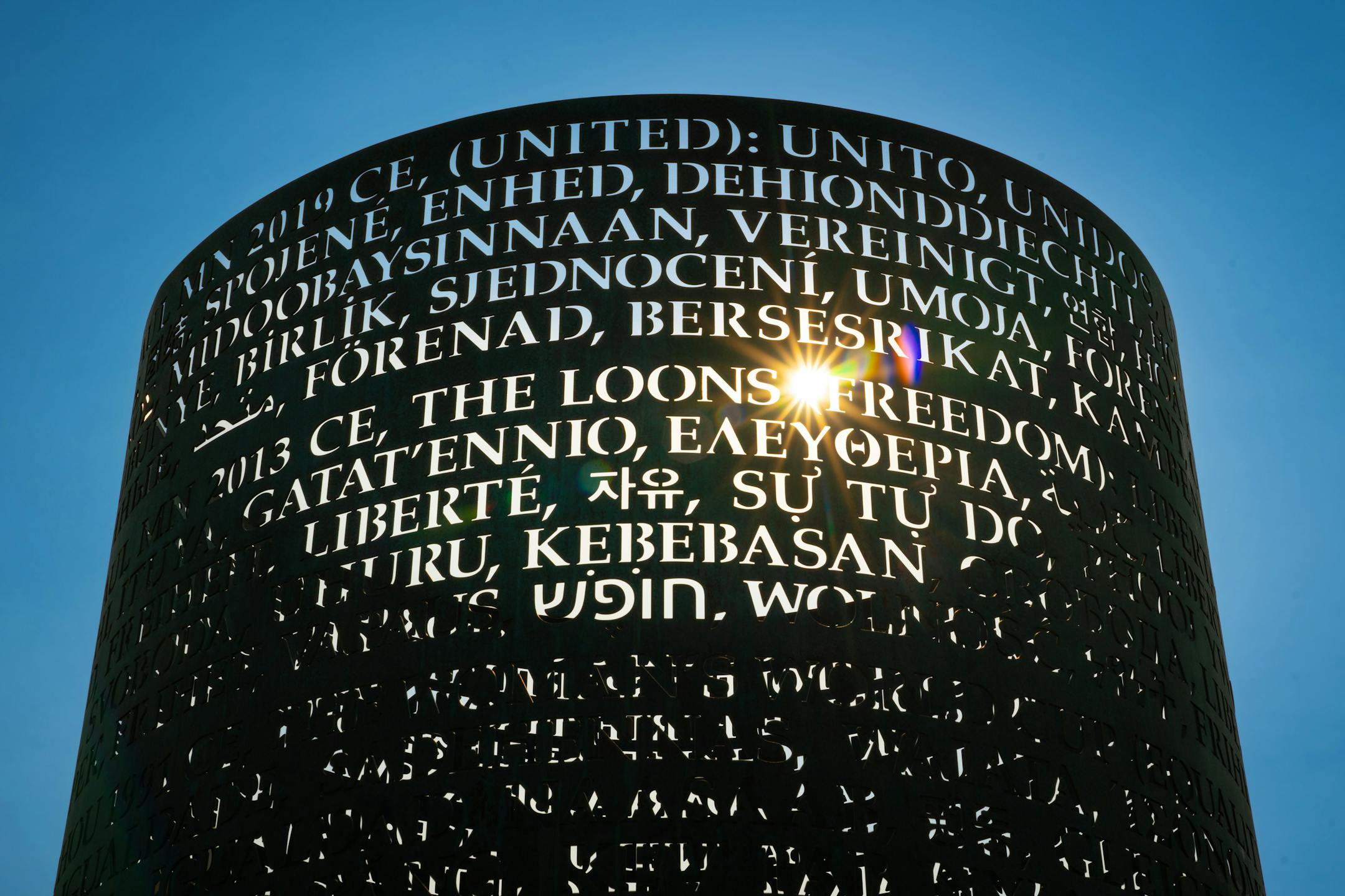 The OMNIS sculpture outside Allianz Stadium in the evening sun before a game with Everton, Wednesday, July 20, 2022, St. Paul, Minn. The OMNIS sculpture by artist Jim Sanborn is located at the north side of Allianz Stadium. It is a cylindrical bronze work with text about the values of soccer written in 80 or so languages; at night, the sculpture lights up from the inside and projects text onto the ground and nearby buildings. The piece was commissioned by Bill McGuire, owner of Minnesota United and former CEO of UnitedHealthcare. ] GLEN STUBBE • glen.stubbe@startribune.com