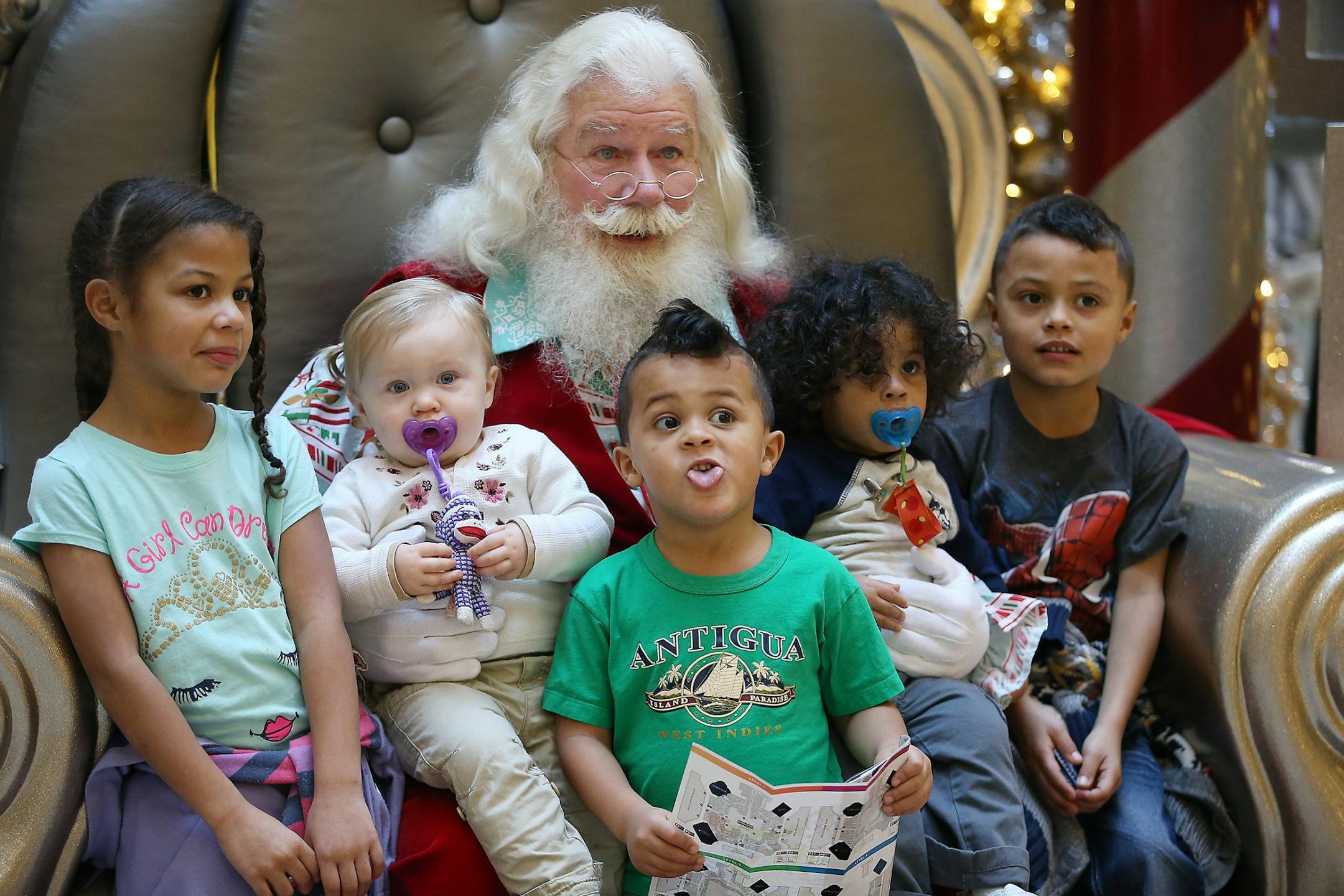 "Santa" sat with Daniella Halstead, 6, from left, Riley Richey, 1, Derek Halstead, 4, Dominic Halstead, 1, and Dante Halstead, 6, as they met him for gift requests and for a photo at the North Pole at the Mall of America, Thursday, December 3, 2015 in Bloomington, MN.