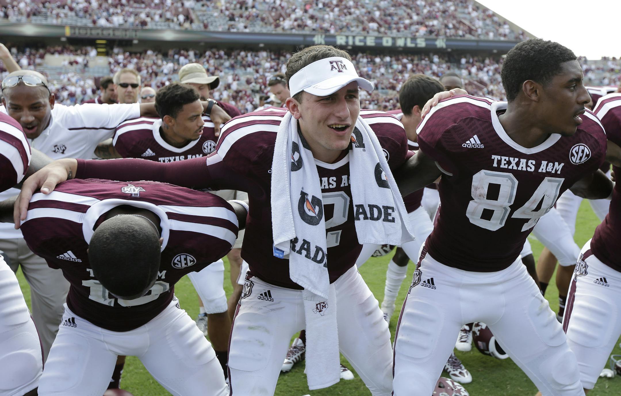 Texas A&M's Johnny Manziel, center with towel, sways with teammates during the school song following an NCAA college football game against Rice, Saturday, Aug. 31, 2013, in College Station, Texas. Manziel missed the first half due to a suspension. (AP Photo/Eric Gay)
