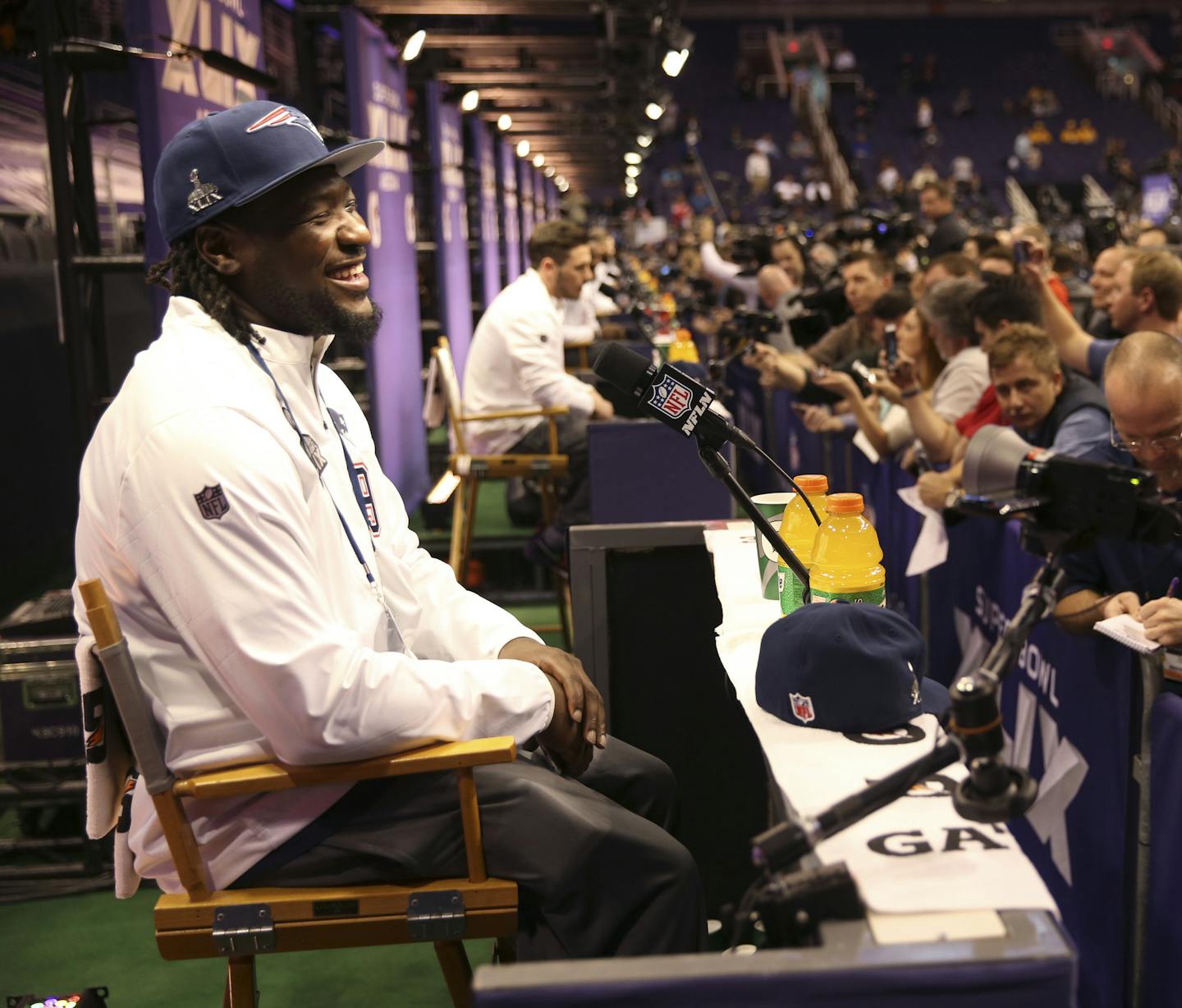 LeGarrette Blount, a running back for the New England Patriots, fields questions during Super Bowl XLIX Media Day, at the U.S. Airways Center in Phoenix, Jan. 27, 2015. Camera crews were tightly packed around podiums for Tom Brady and other key figures on the Patriots, while other parts of the event floor were mostly ghost towns by comparison. (Doug Mills/The New York Times)