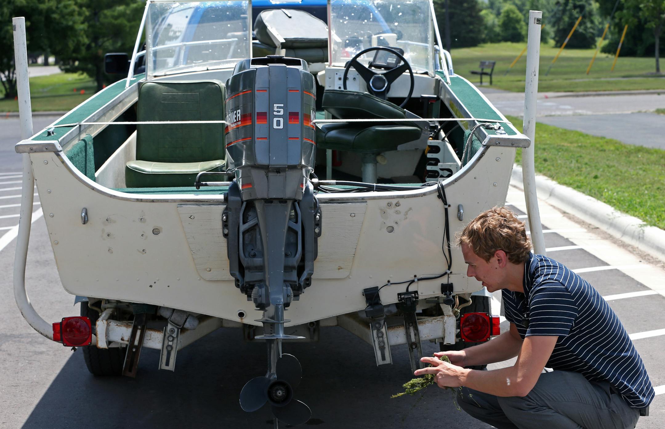 Adam Doll, DNR Watercraft Inspectin Supervisor, demonstrated the correct way to clean a boat of weeds and how to drain live wells during a press conference announcing that the DNR is setting up 200 new clean and drain areas at boat launches around the state. They are hoping the cleaning areas will slow the spread of invasive species. Photographed on 7/16/13 at the Jaycee Park boat landing in Hastings, MN.] Bruce Bisping/Star Tribune bbisping@startribune.com Adam Doll/source.