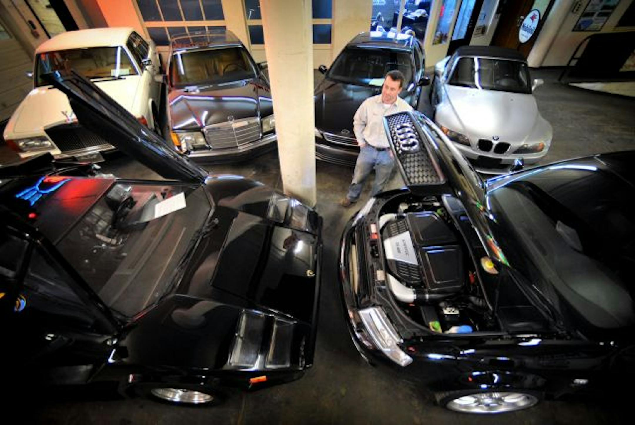 Six of jailed money manager Trevor Cook's cars, which will be up for auction Saturday in downtown Minneapolis, surrounded Matt Rabanus of Classic Auto Storage. Most are high-mileage, relatively low-value cars. But the one in the front right is the real prize of the bunch, a highly modified Audi screamer that Cook bought from a financial expert in Switzerland. It's expected to fetch more than $30,000.