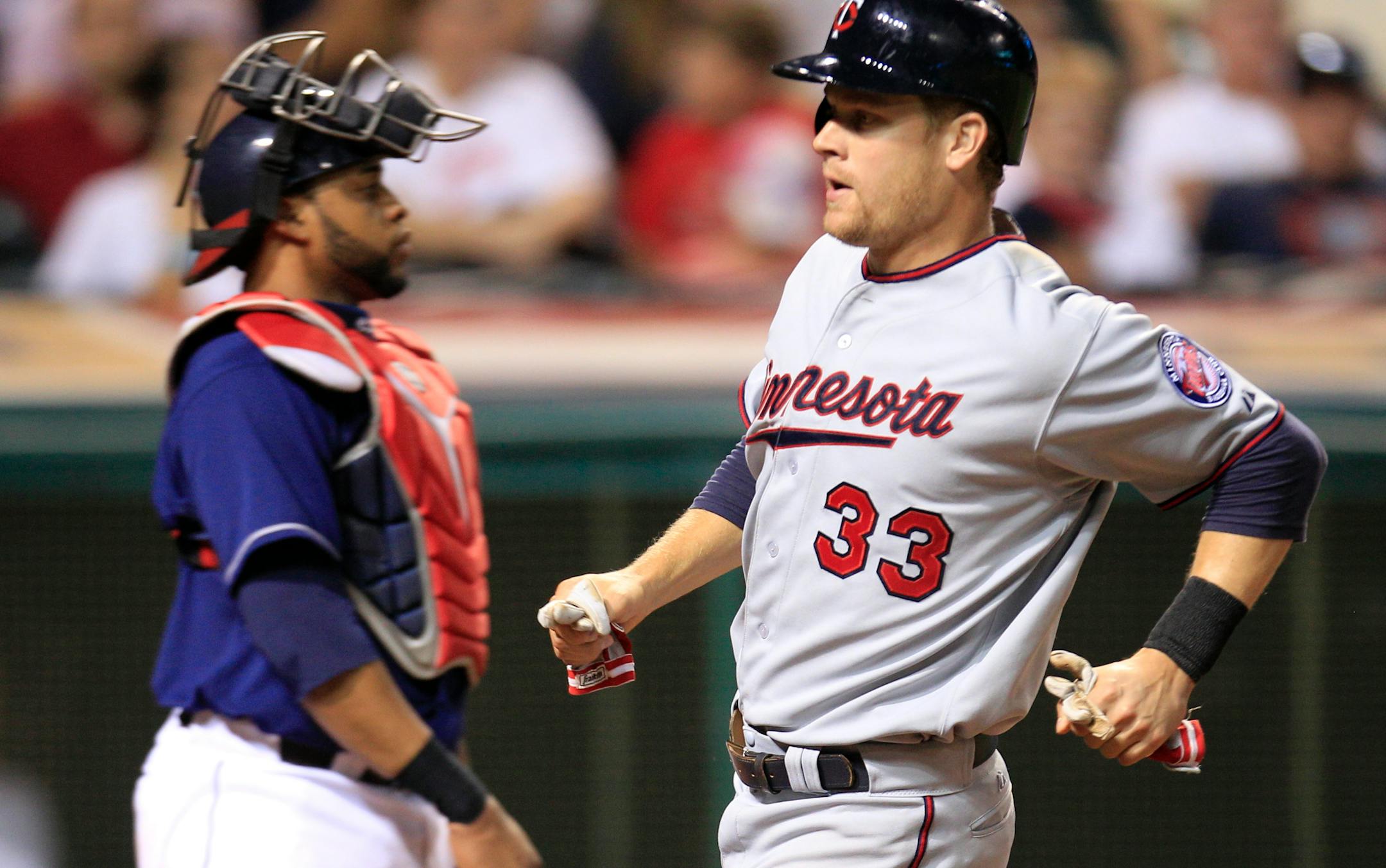 The Twins' Justin Morneau, right, scored the go-ahead run in the ninth inning on Tsuyoshi Nishioka's sacrifce fly as Cleveland catcher Carlos Santana could only wait for the throw home.