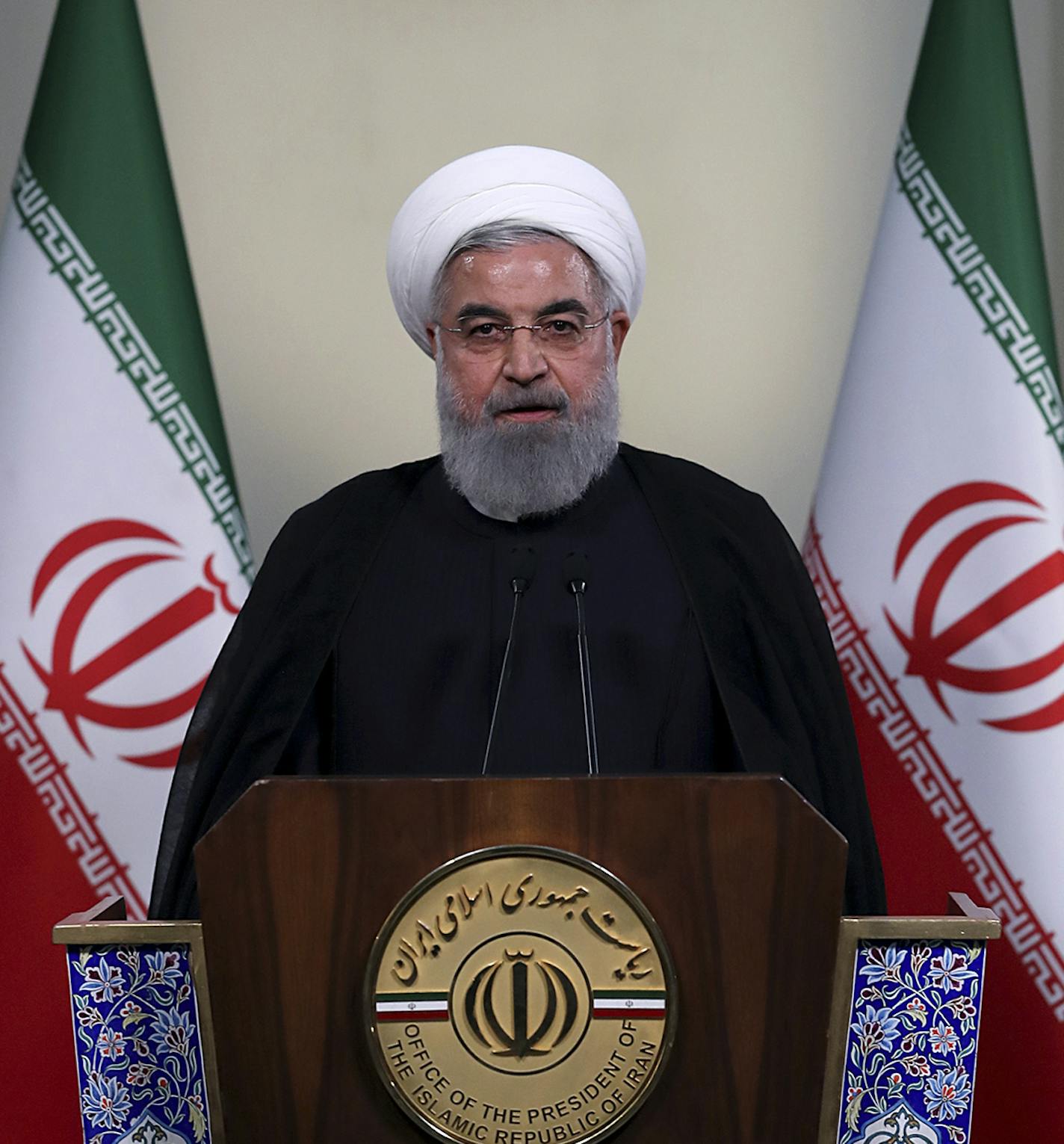 In this photo released by official website of the office of the Iranian Presidency, President Hassan Rouhani addresses the nation in a televised speech in Tehran, Iran, Tuesday, May 8, 2018. Iranian President Hassan Rouhani said Tuesday he'd send his foreign minister to negotiate with countries remaining in the nuclear deal after Donald Trump's decision to pull America from the deal, warning he otherwise would restart enriching uranium "in the next weeks." (Iranian Presidency Office via AP)